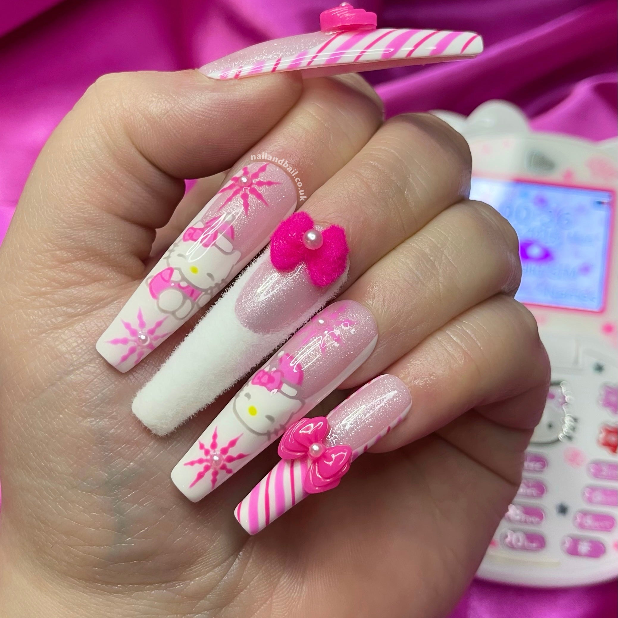 Meet 'Kitty’s Candy Land' press-on nails – a festive fusion of pink shimmer bases, white French tips, and hand-painted candy cane stripes. Adorned with Hello Kitty in a pink Santa hat amidst pink snowflakes, and featuring furry French tips with a dark pink bow, these nails are a quick and chic way to embrace holiday sweetness. Ready to dazzle in minutes!