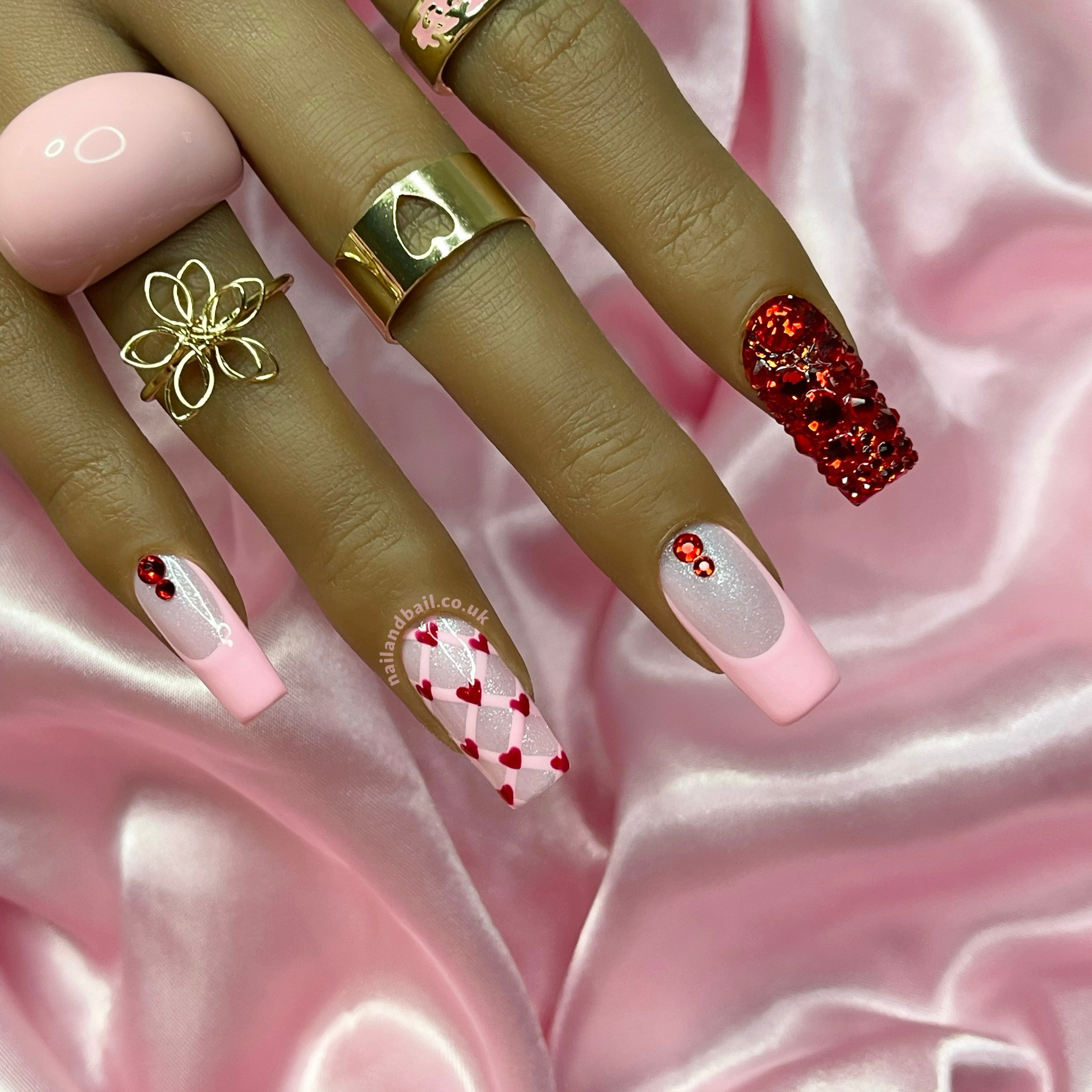 Introducing "Rosy Romance" press-on nails - your ticket to instant glamour and girly charm! Featuring pale pink shimmer bases with baby pink French tips and red crystals on select nails, these nails are all about spreading the love with hand-painted pink crisscrosses and adorable red hearts. Complete with fully decked-out red crystal pointer nails, these beauties are perfect for any occasion. Get ready to sparkle and shine with "Rosy Romance"! 💅❤️