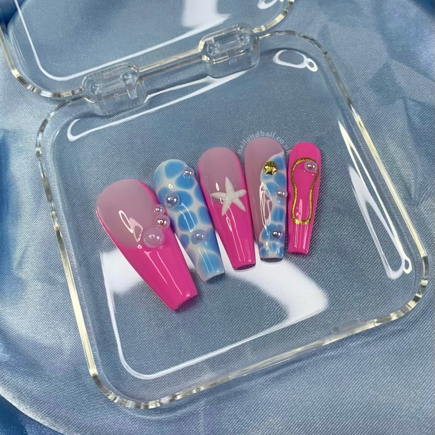 Get summer-ready with the “Pool Party” Press On Nail Set! Featuring vibrant pink and blue pool designs with pearls, starfish, and gold shells, these nails bring chic, beachy glamour to any look. Effortlessly stylish and perfect for sunny days!