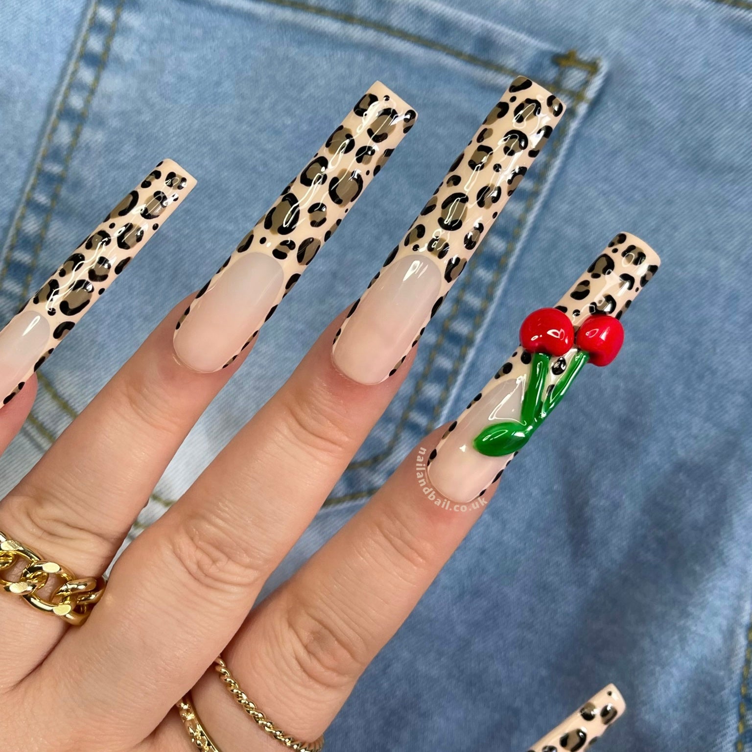 "Cherry Slater" Press-On Nails blend Y2K nostalgia with modern flair. Hand-painted leopard print French tips and 3D cherries add playful charm to any look, offering effortless style and individuality.