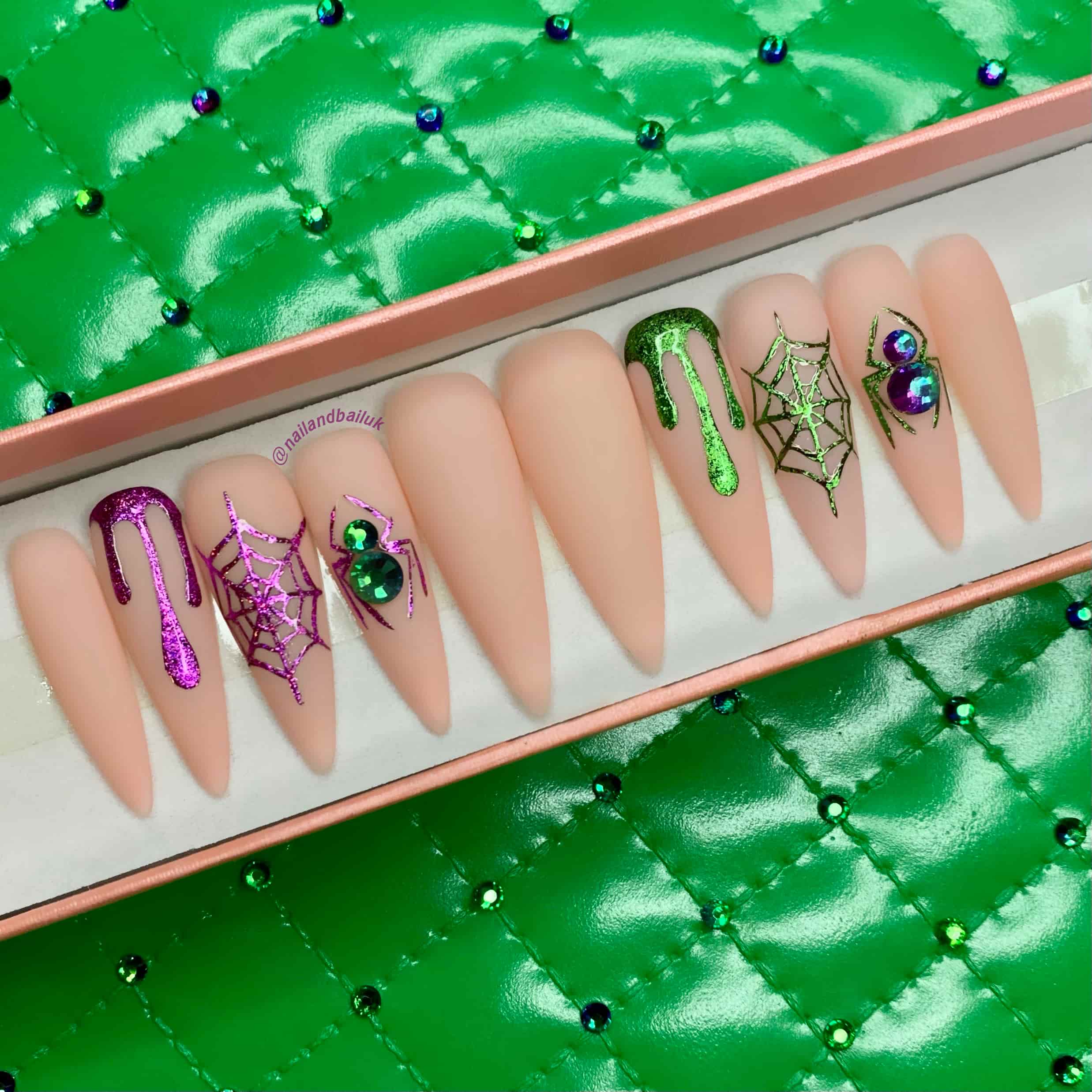Matte nude press-on nails with purple and green chrome drips, spider webs, and crystal spiders