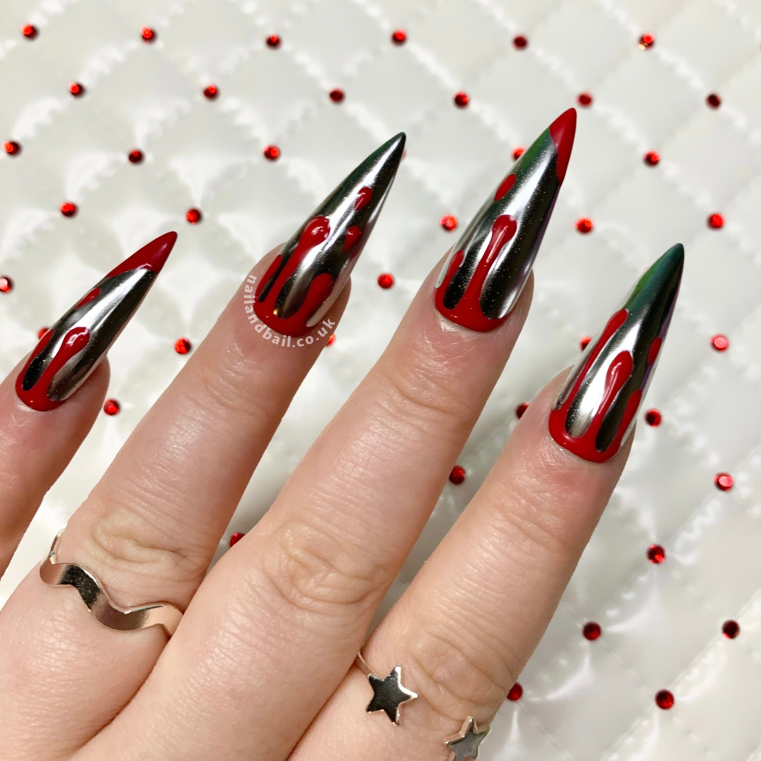 Hand-painted red blood drip nail art on silver chrome press-on nails