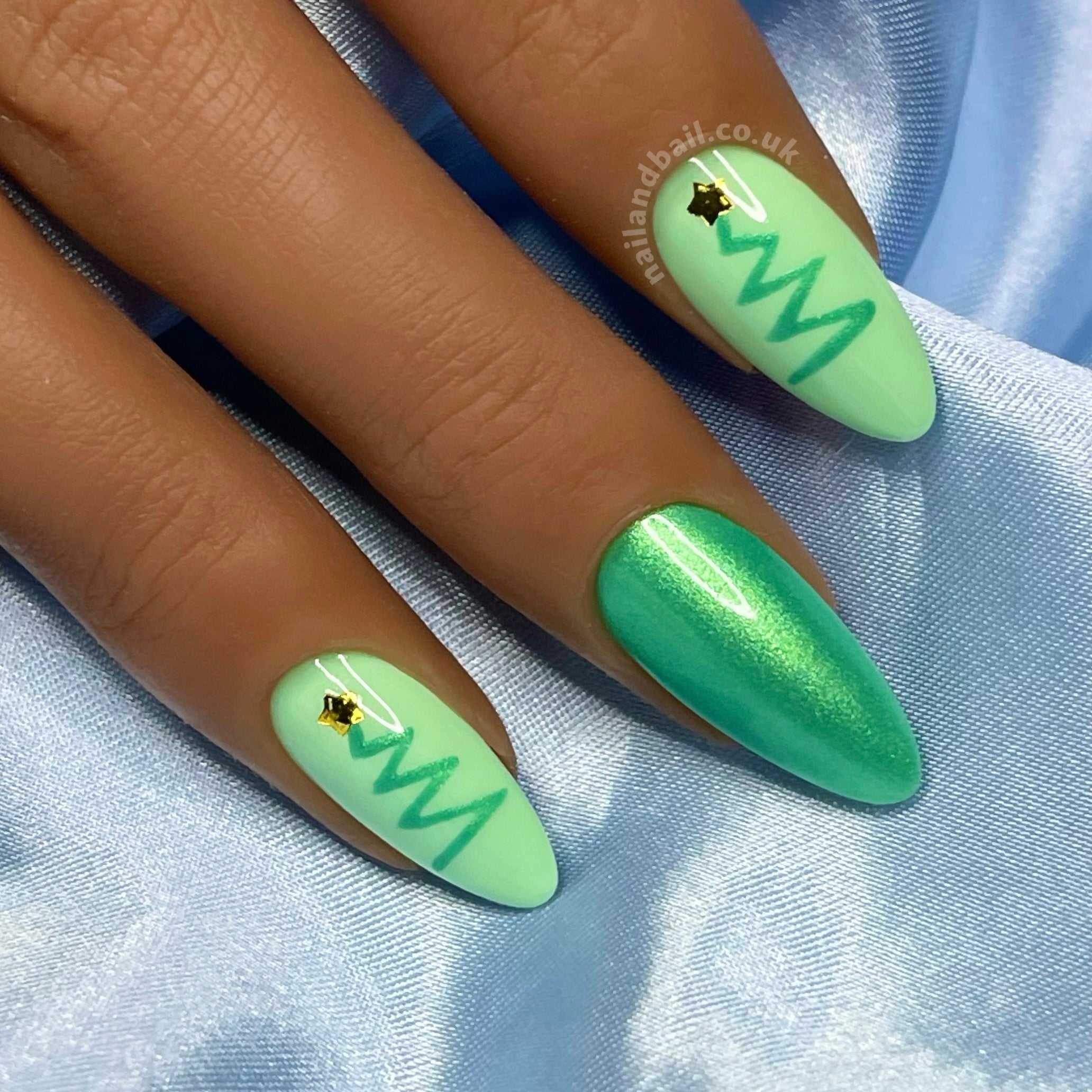 Hand-painted Christmas tree nail art on green shimmer festive press-on nails