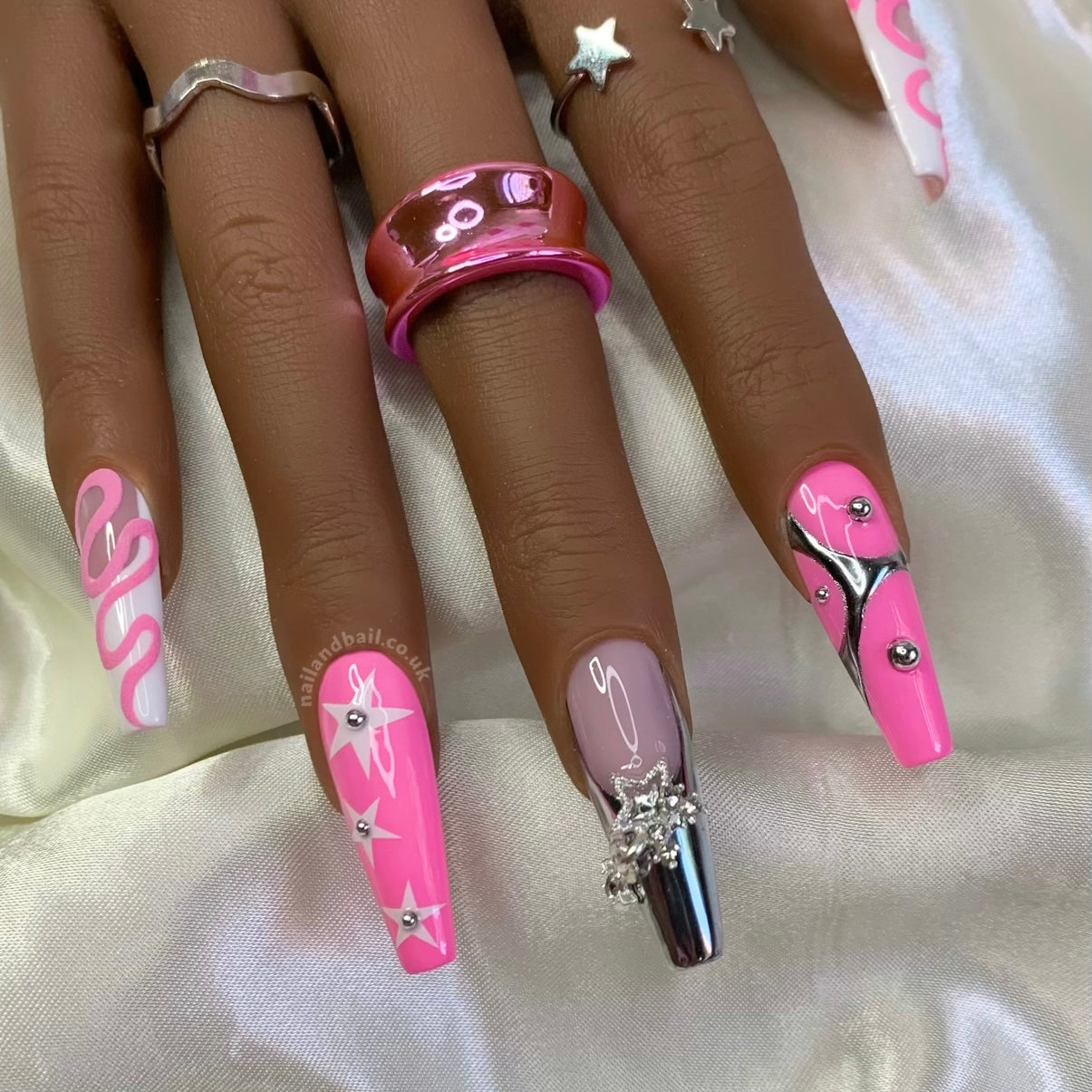 Silver French tip press-on nails with pink swirl nail art and star charms
