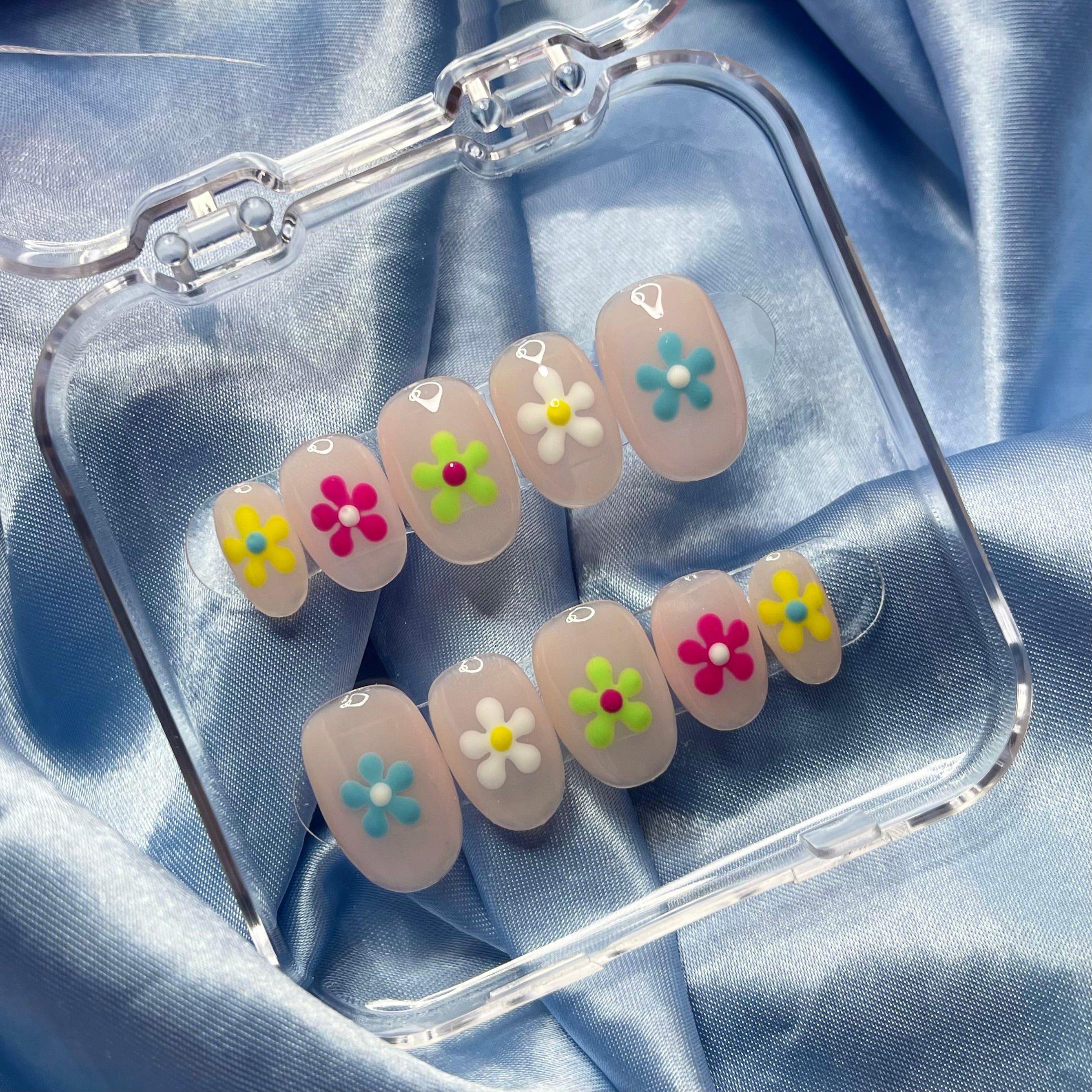 Nude press-on nails with colourful hand-painted flower nail art and contrasting floral centres