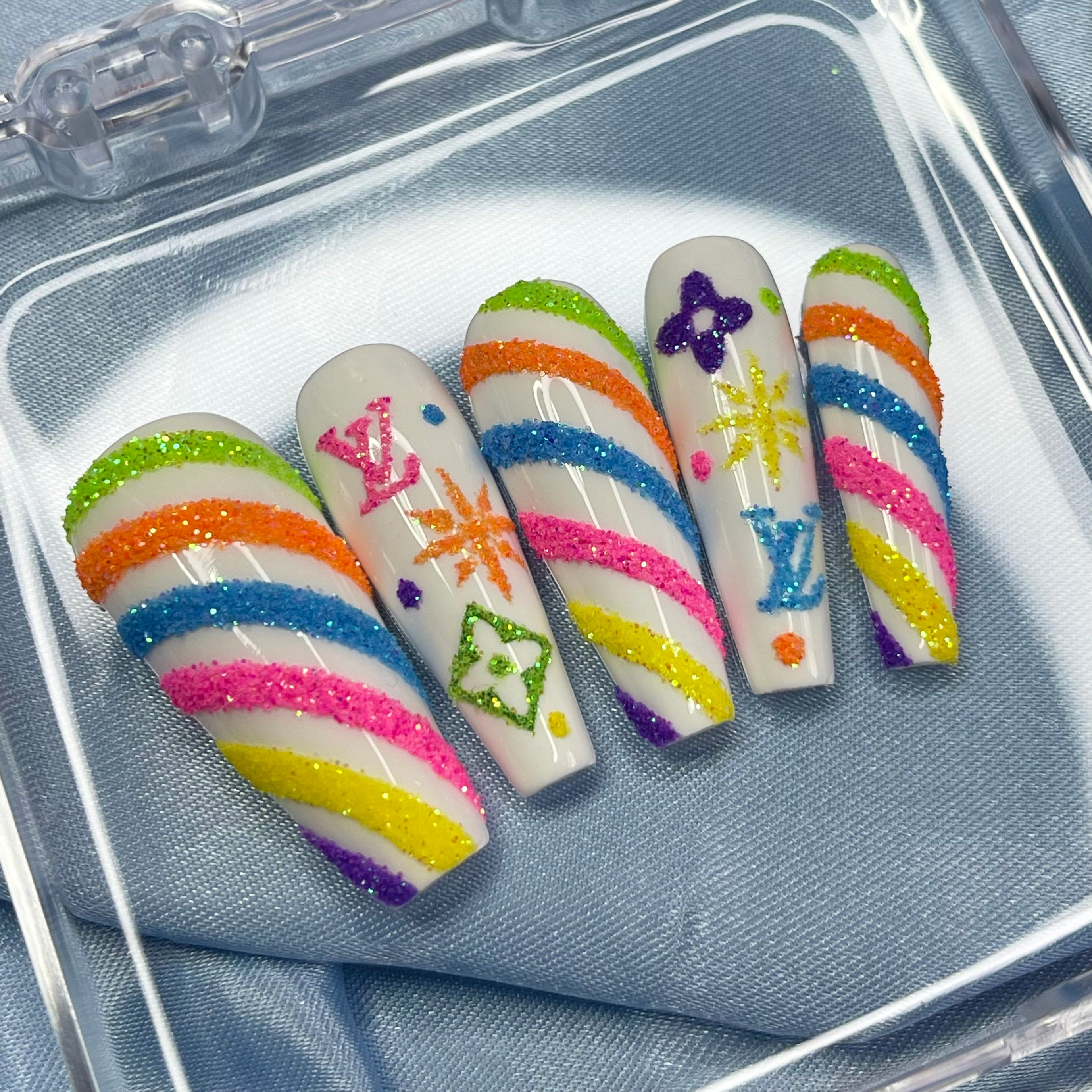 Multi-coloured glitter candy cane stripe nail art on white Christmas press-on nails