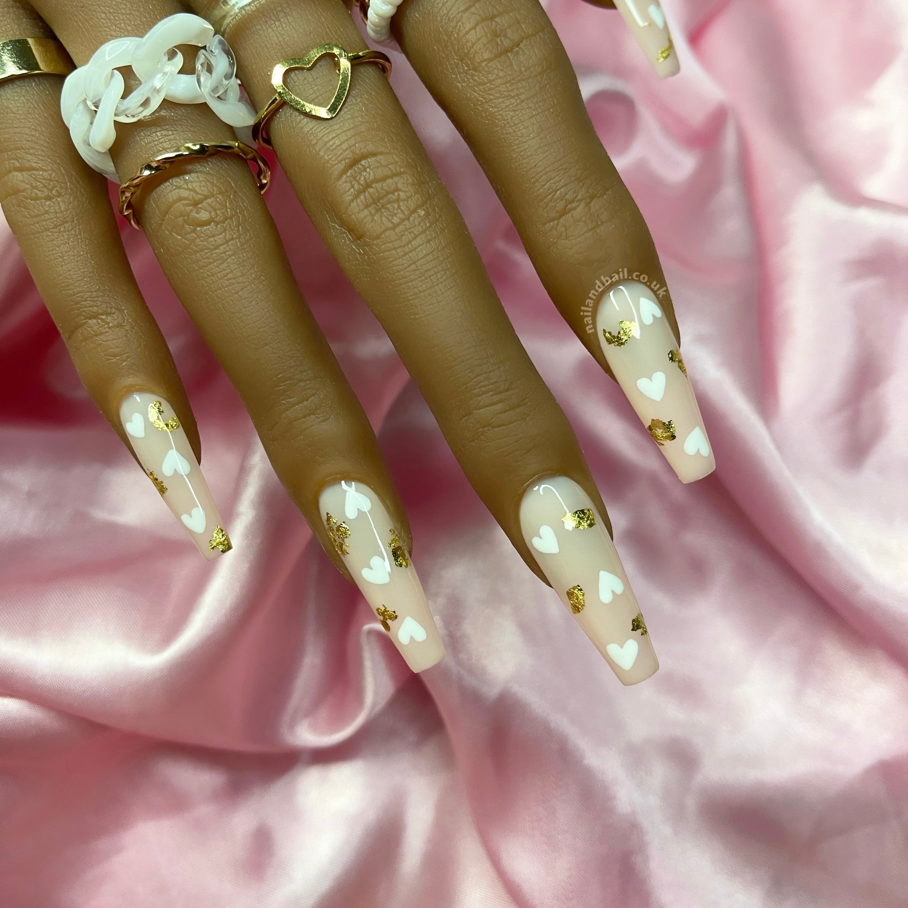 Gold leaf nail art on nude press-on nails with white hearts