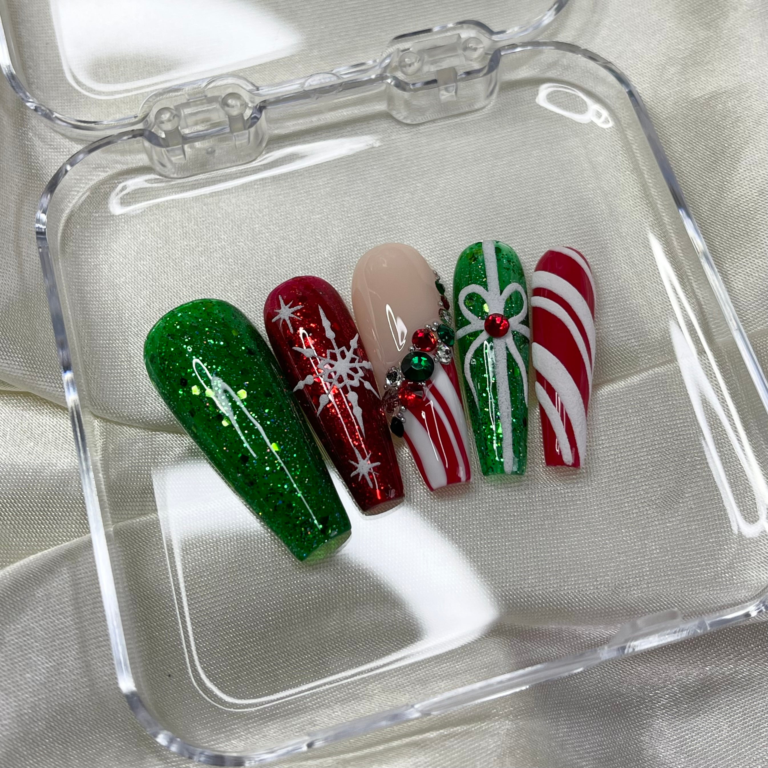 Candy cane French tip press-on nails with red, green, and silver crystal details