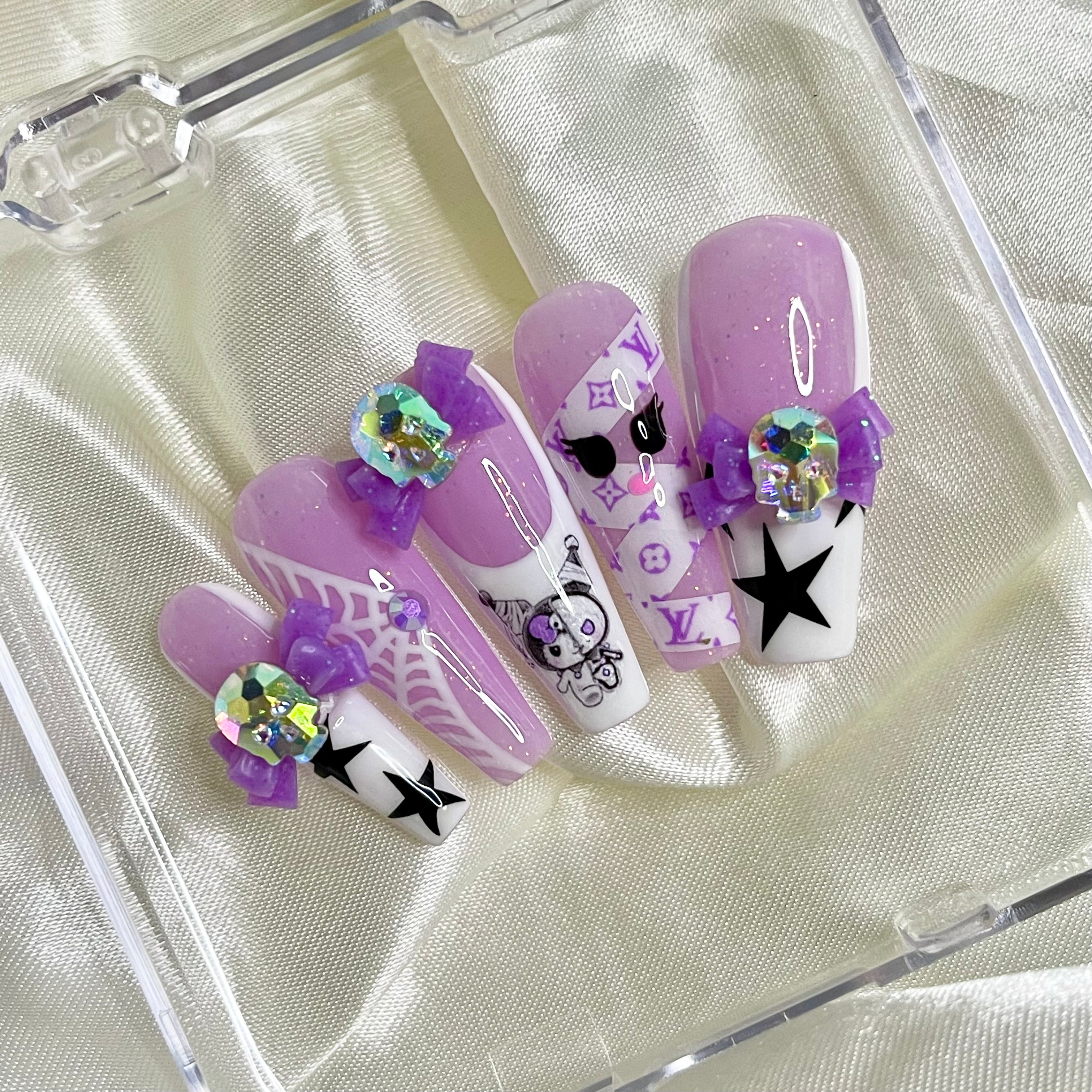 Kawaii horror press-on nails with purple glitter, mummy Kuromi nail art, white French tips, skull bows, and spiderweb details
