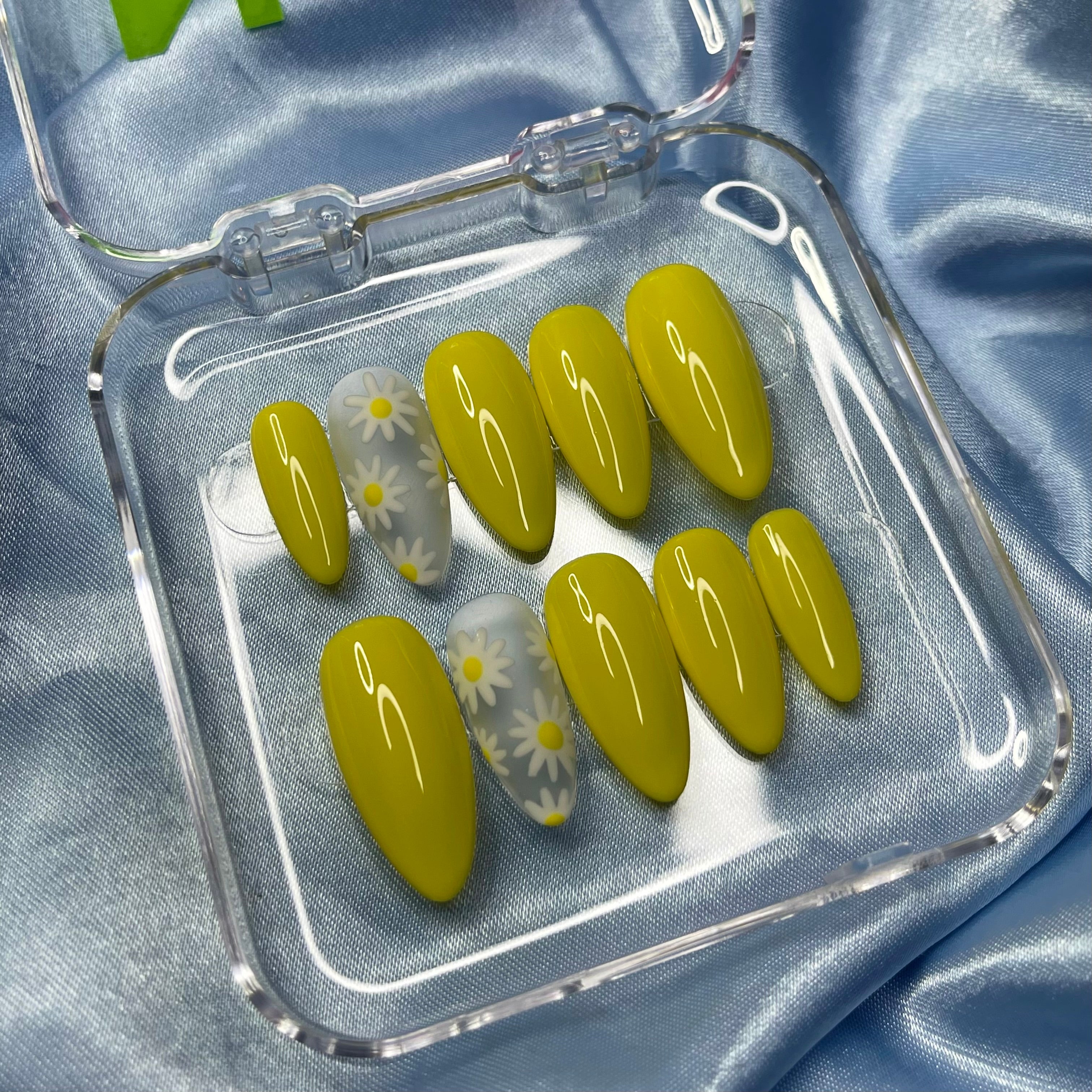 Yellow press-on nails with hand-painted daisy flowers on clear matte accent nails