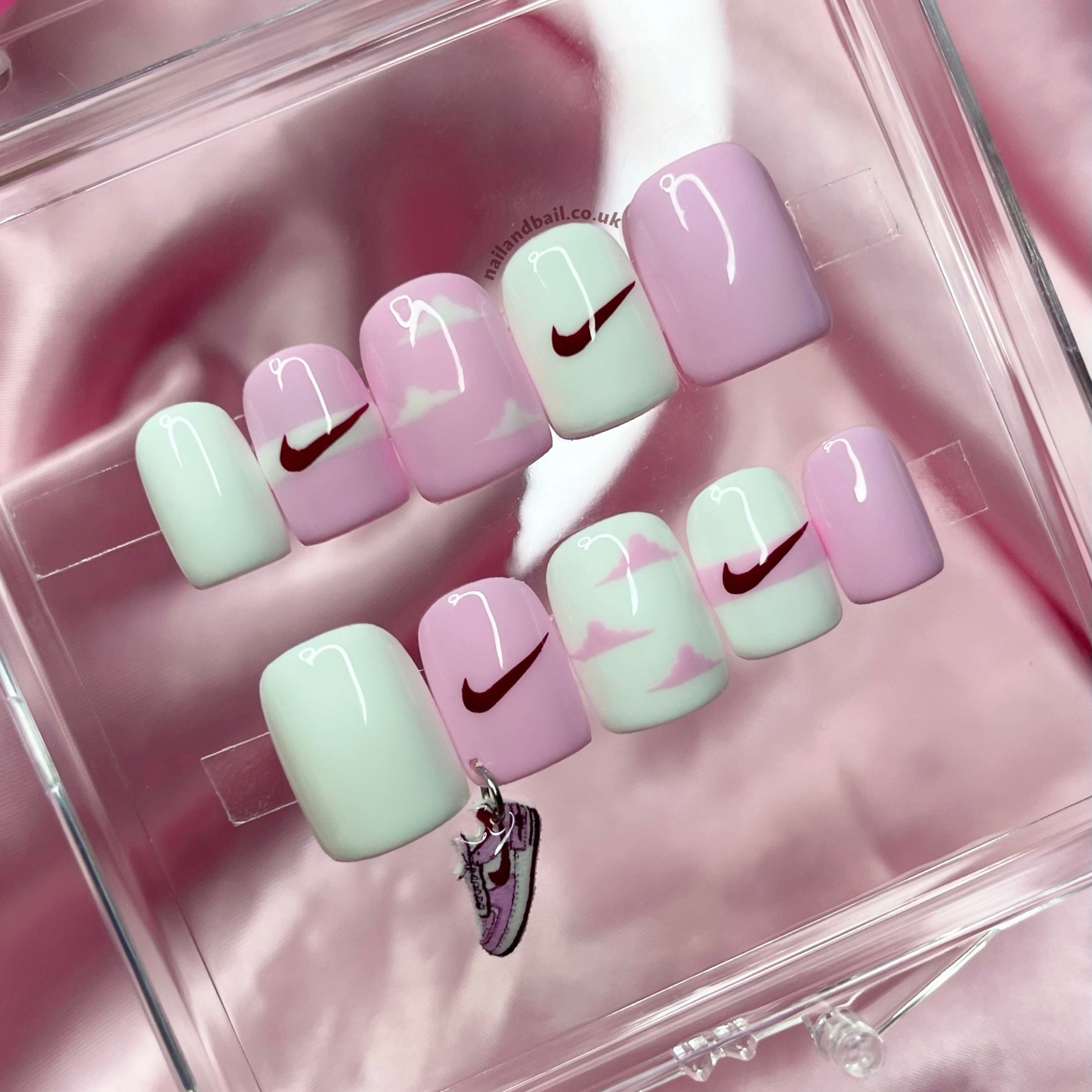 Pink and white sporty press-on nails with cloud nail art and handmade sneaker charm