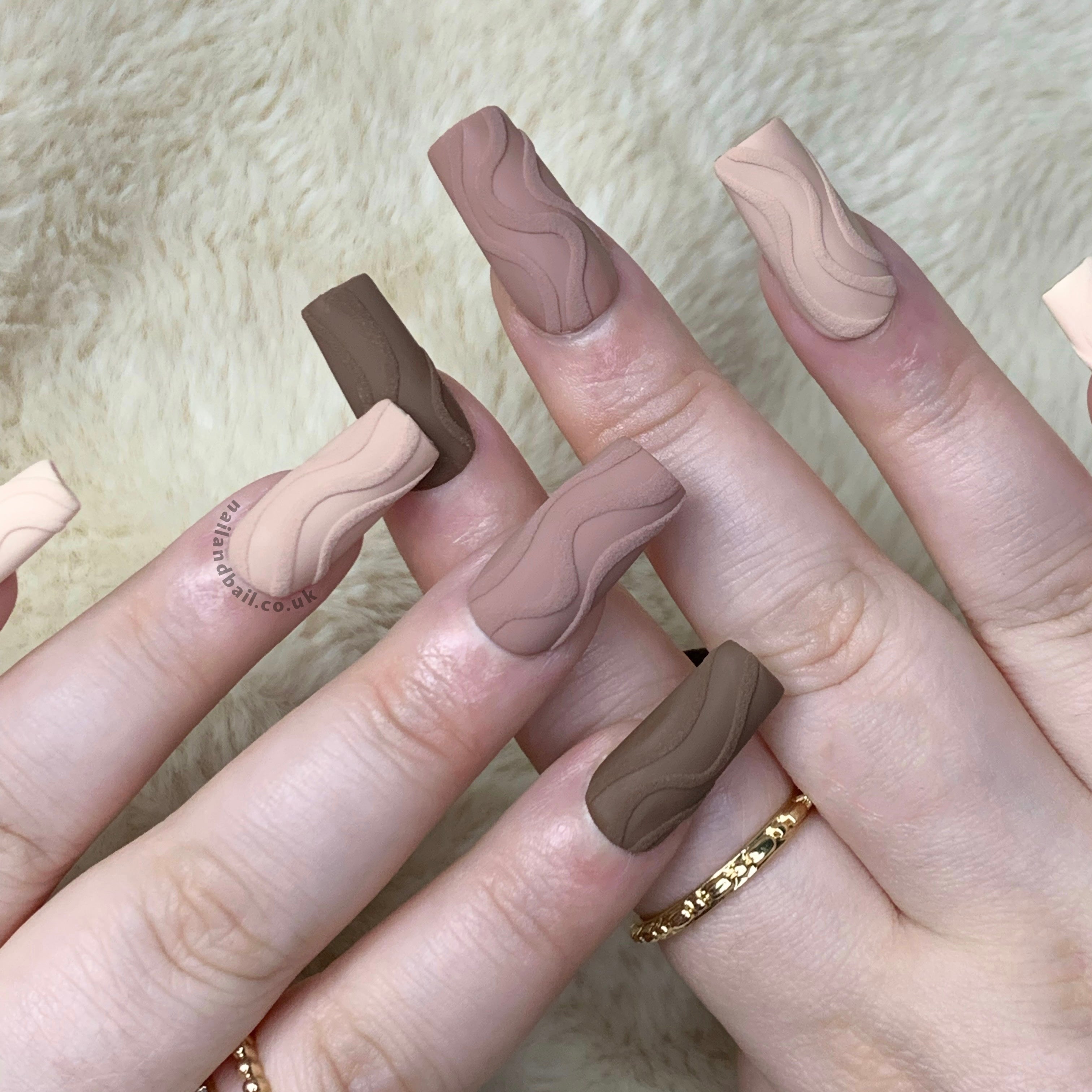 Nude press-on nails with embossed swirl nail art and elegant neutral autumn details