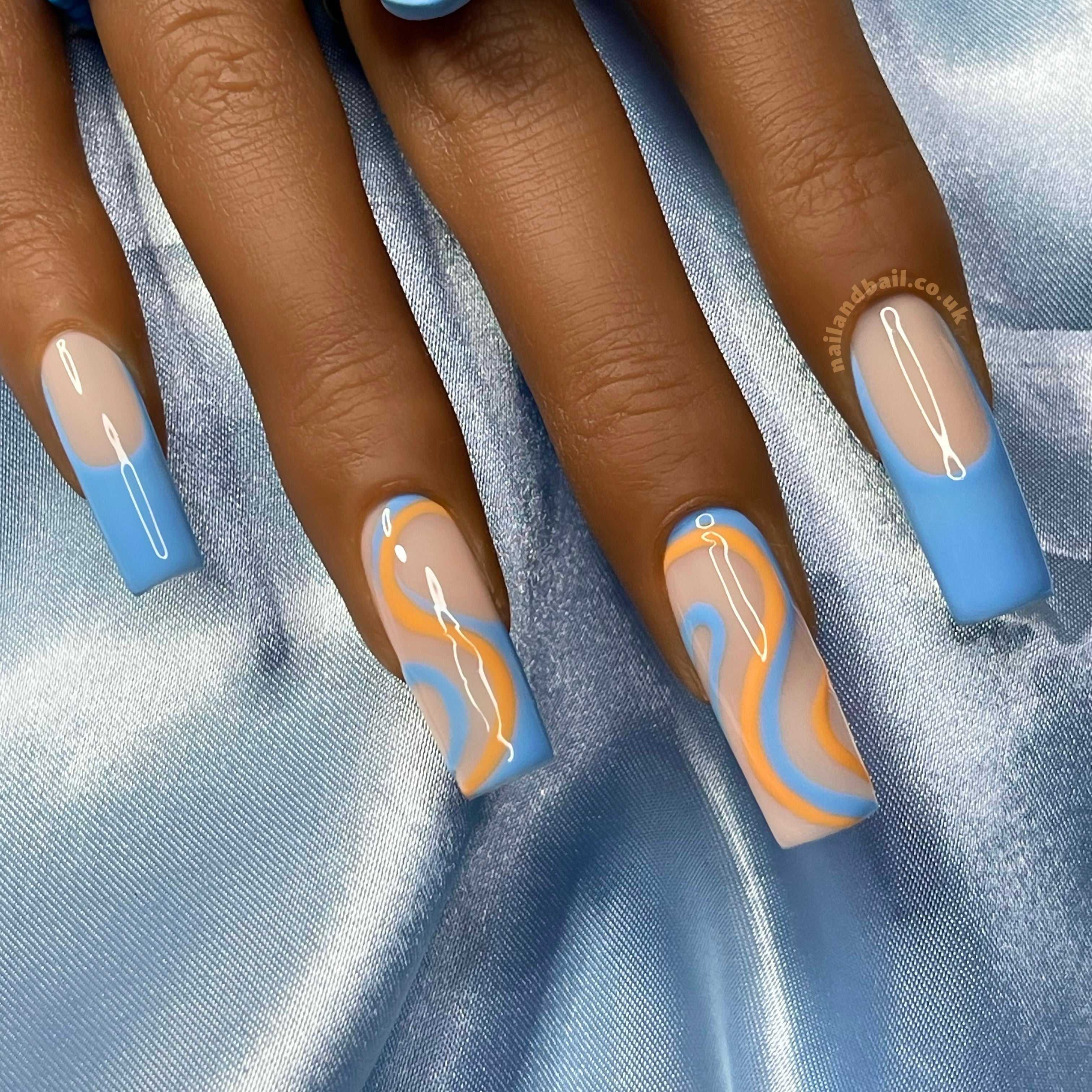 Orange and blue swirl nail art on glossy summer press-on nails