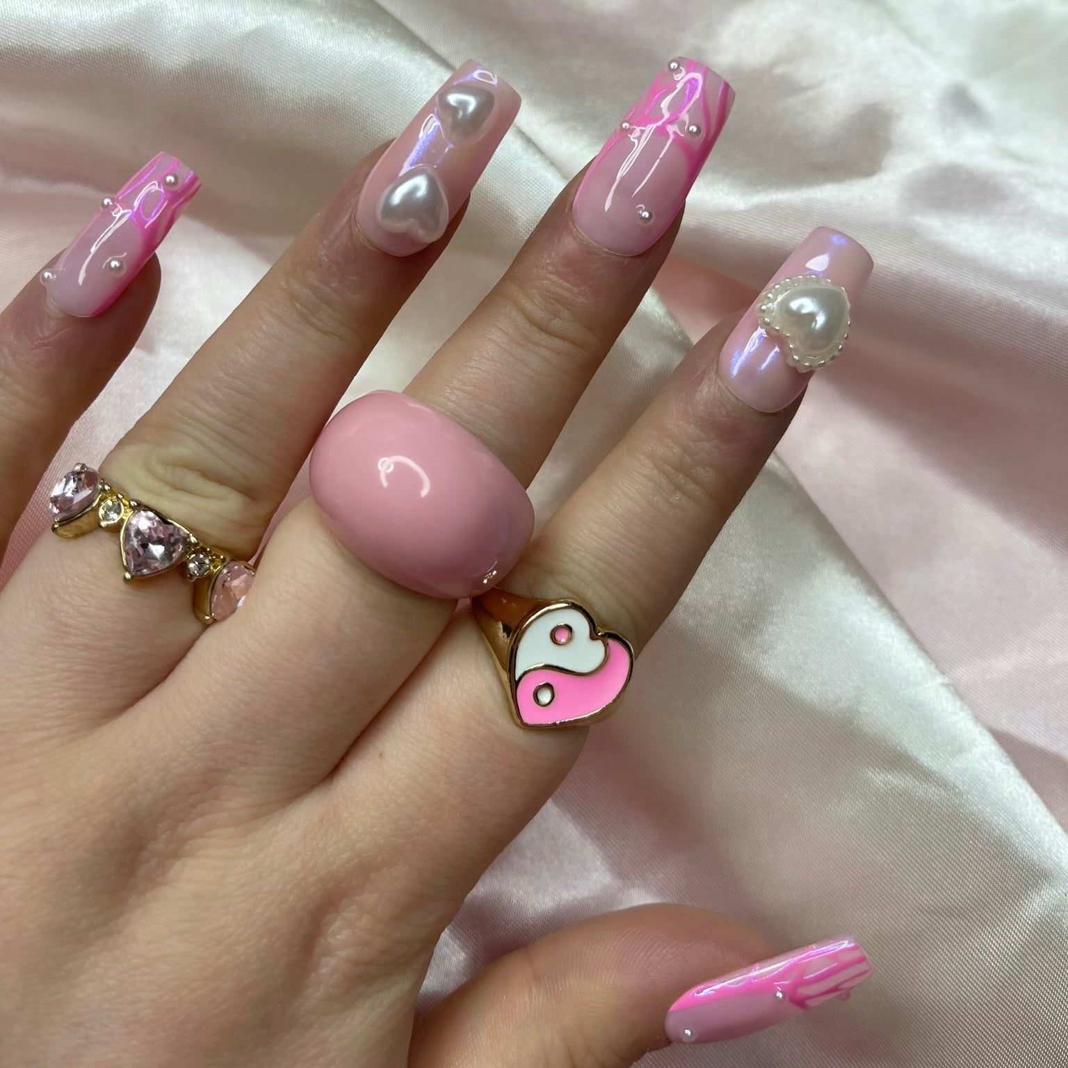 Pink chrome French tip press-on nails with swirl nail art on nude base
