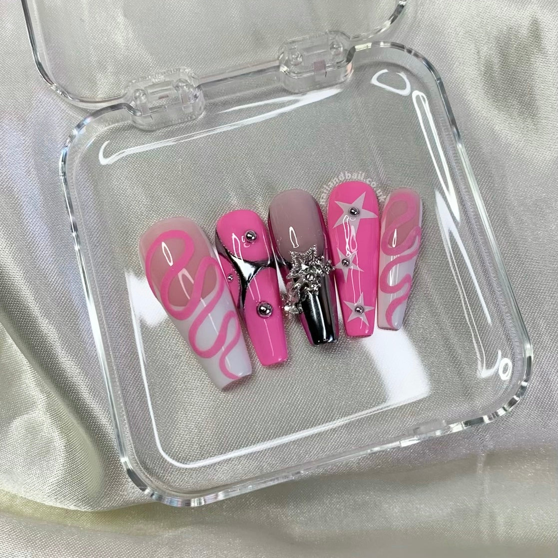Pink swirl nail art on futuristic silver French tip press-on nails