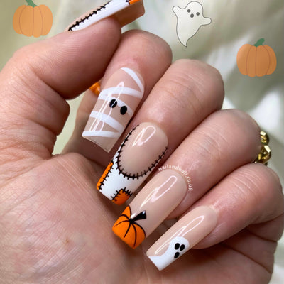 Halloween press-on nails with pumpkin nail art, ghosts, mummies, and patchwork French tips