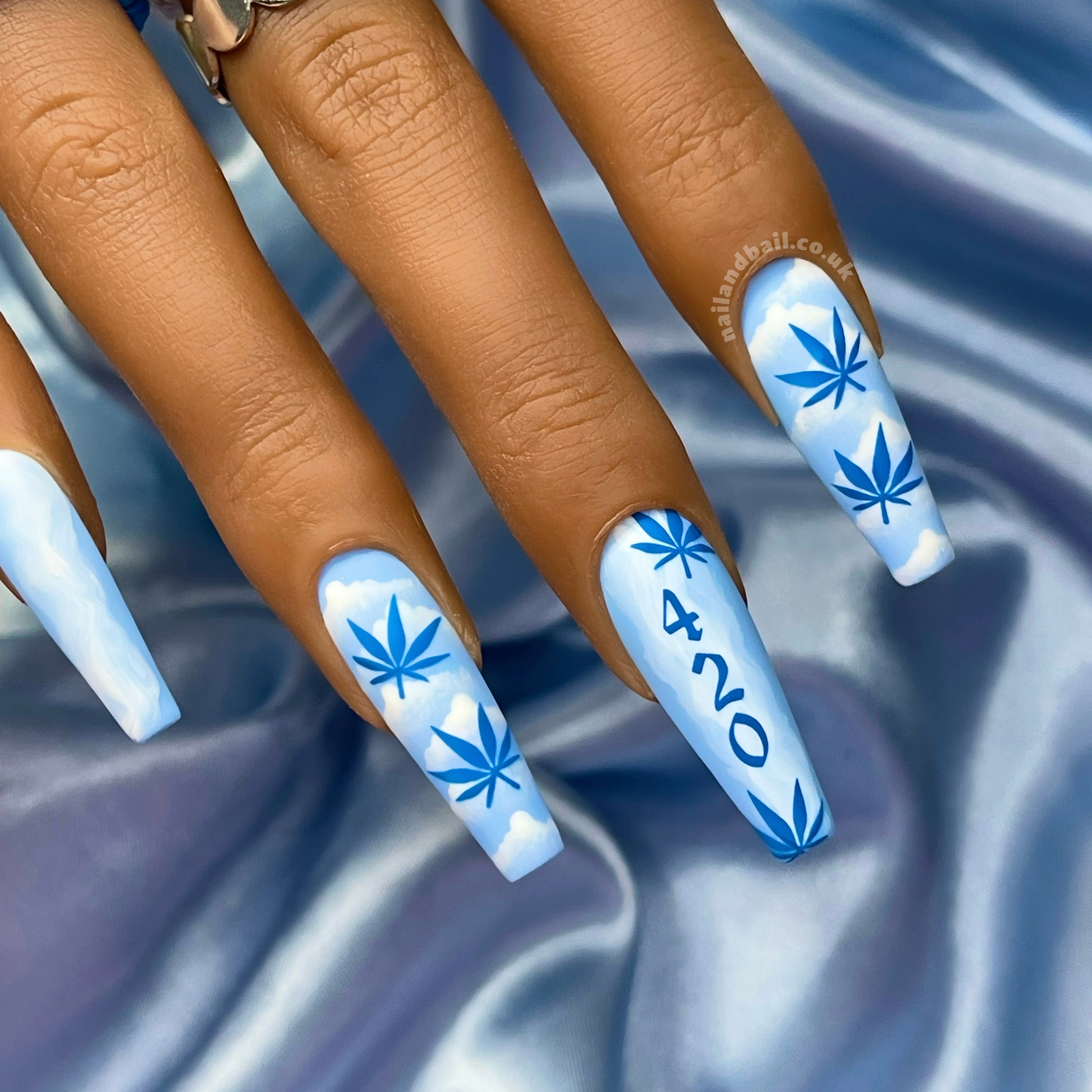 Blue press-on nails with cloud nail art, smoke details, and leaf-inspired nail designs