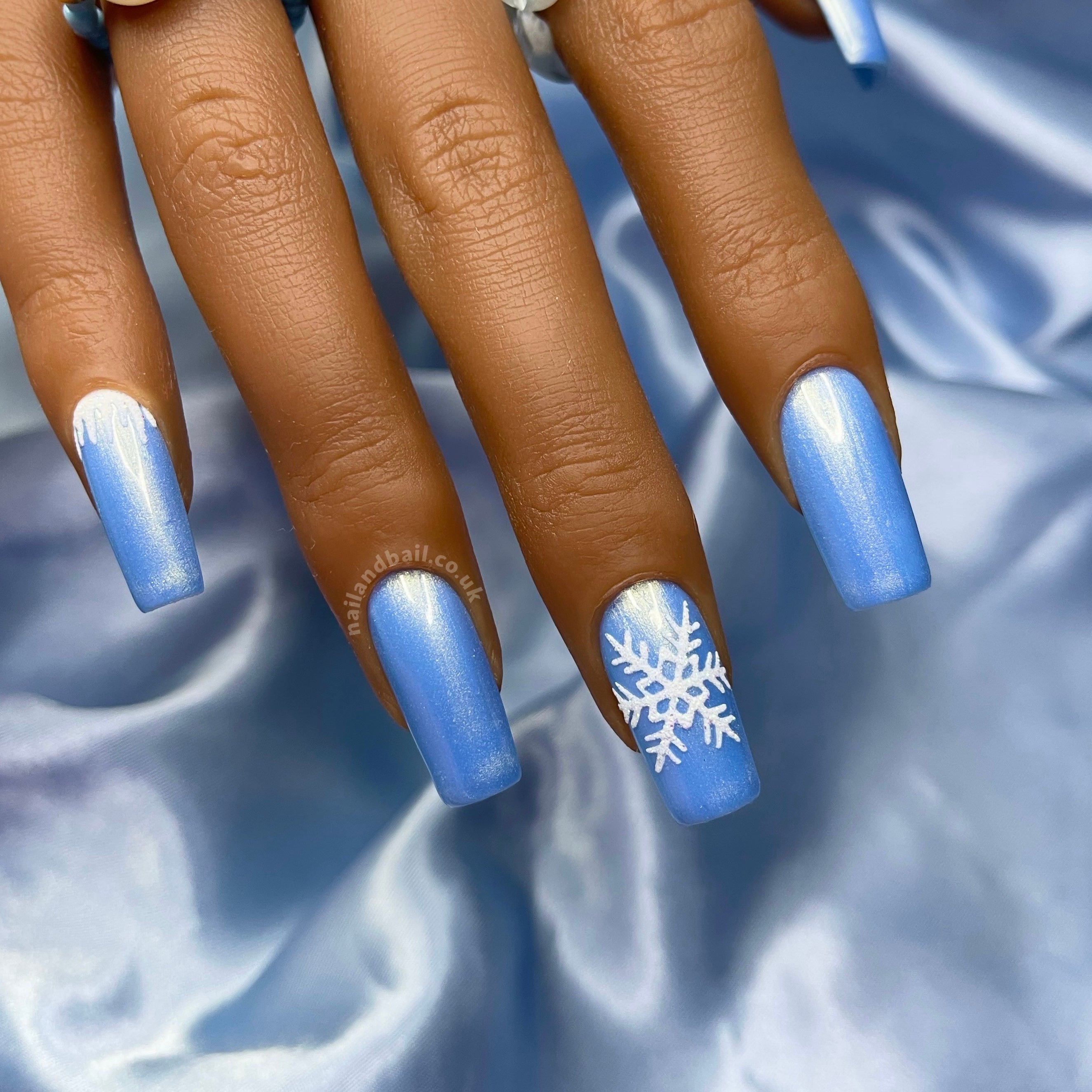 Light blue shimmer press-on nails with glitter icicle nail art and white snowflakes
