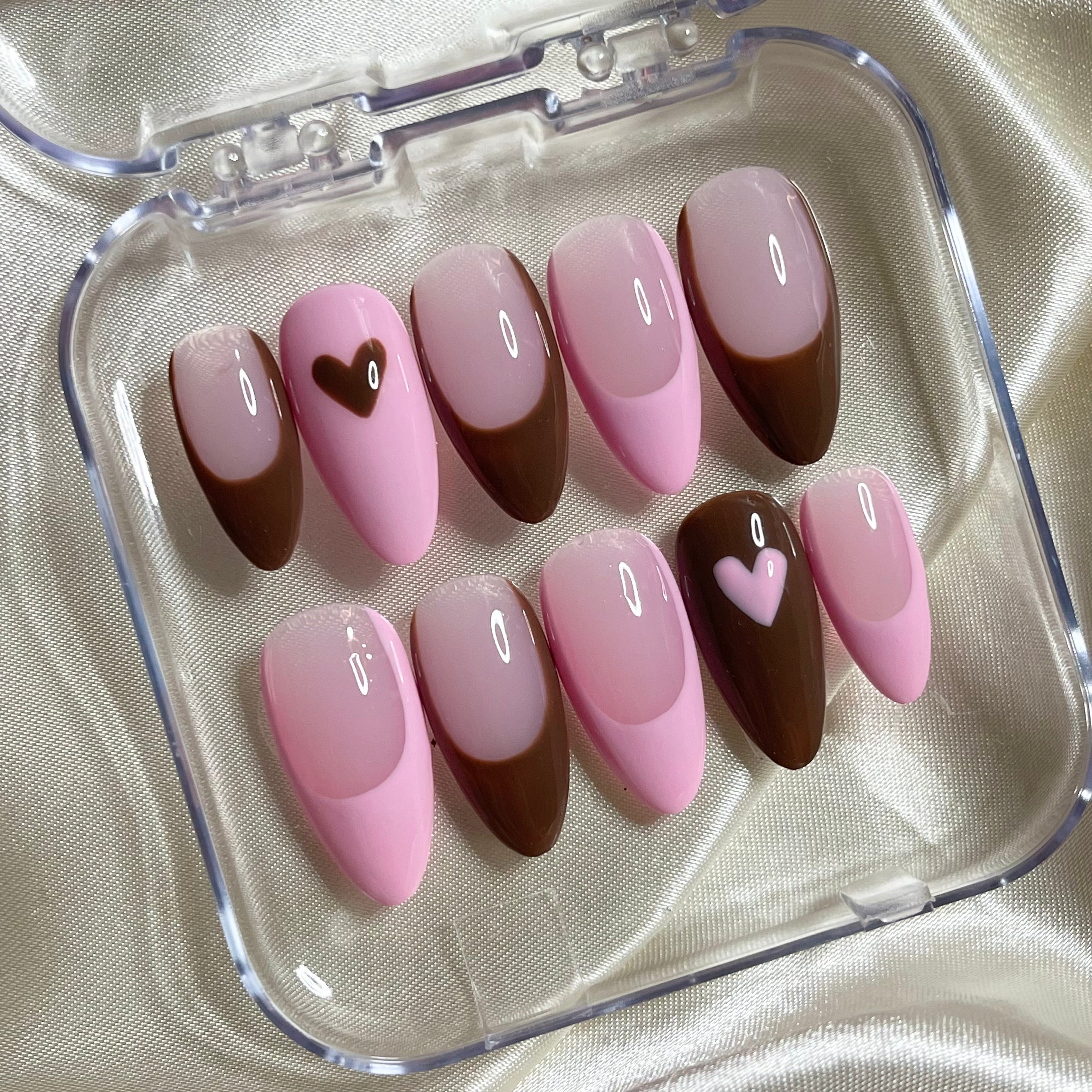 Pink nude press-on nails with brown and baby pink French tips and heart accent nail art