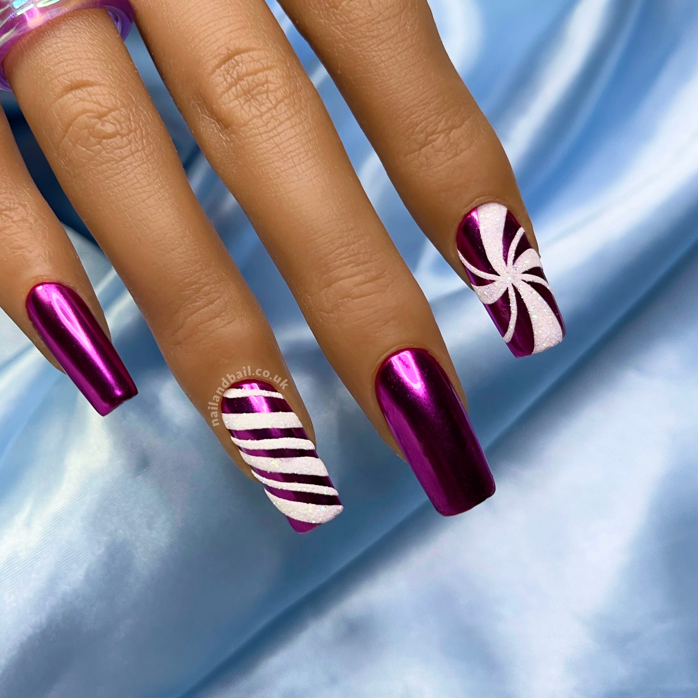 Purple chrome press-on nails with glitter candy cane nail art and festive winter details