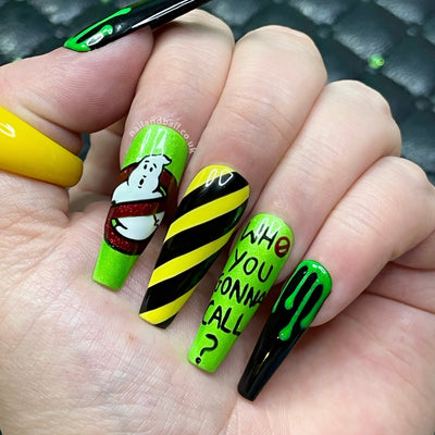 Horror-inspired press-on nails with green slime details, bold stripes, and spooky logo nail art