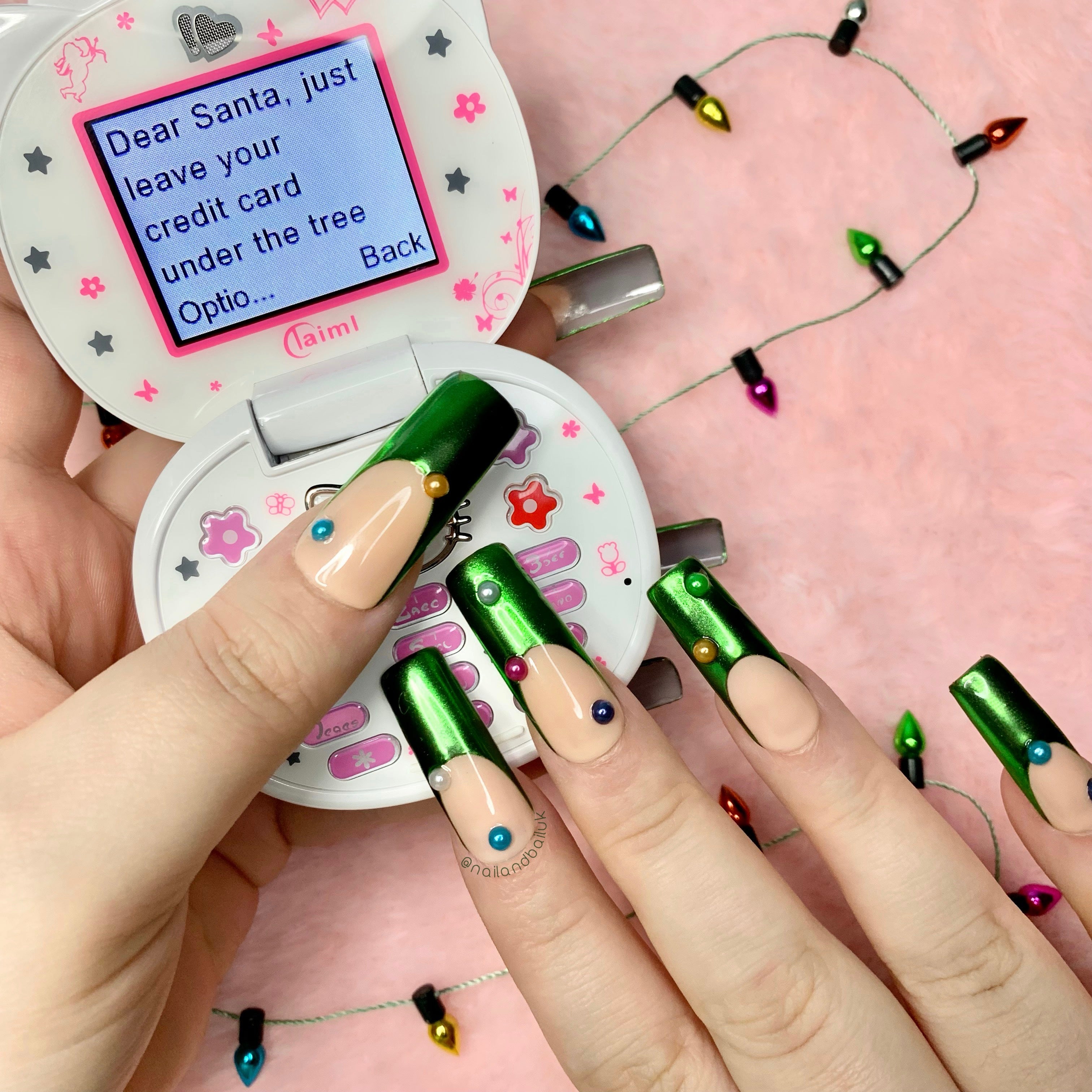 Nude press-on nails with green chrome French tips and colourful pearl embellishments