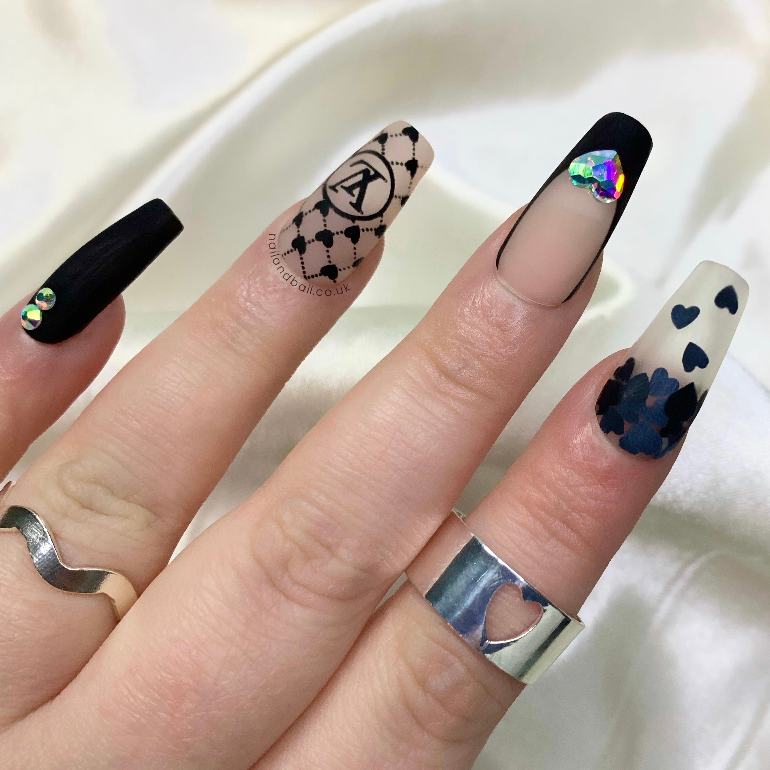 Black heart nail art on matte black French tip press-on nails
