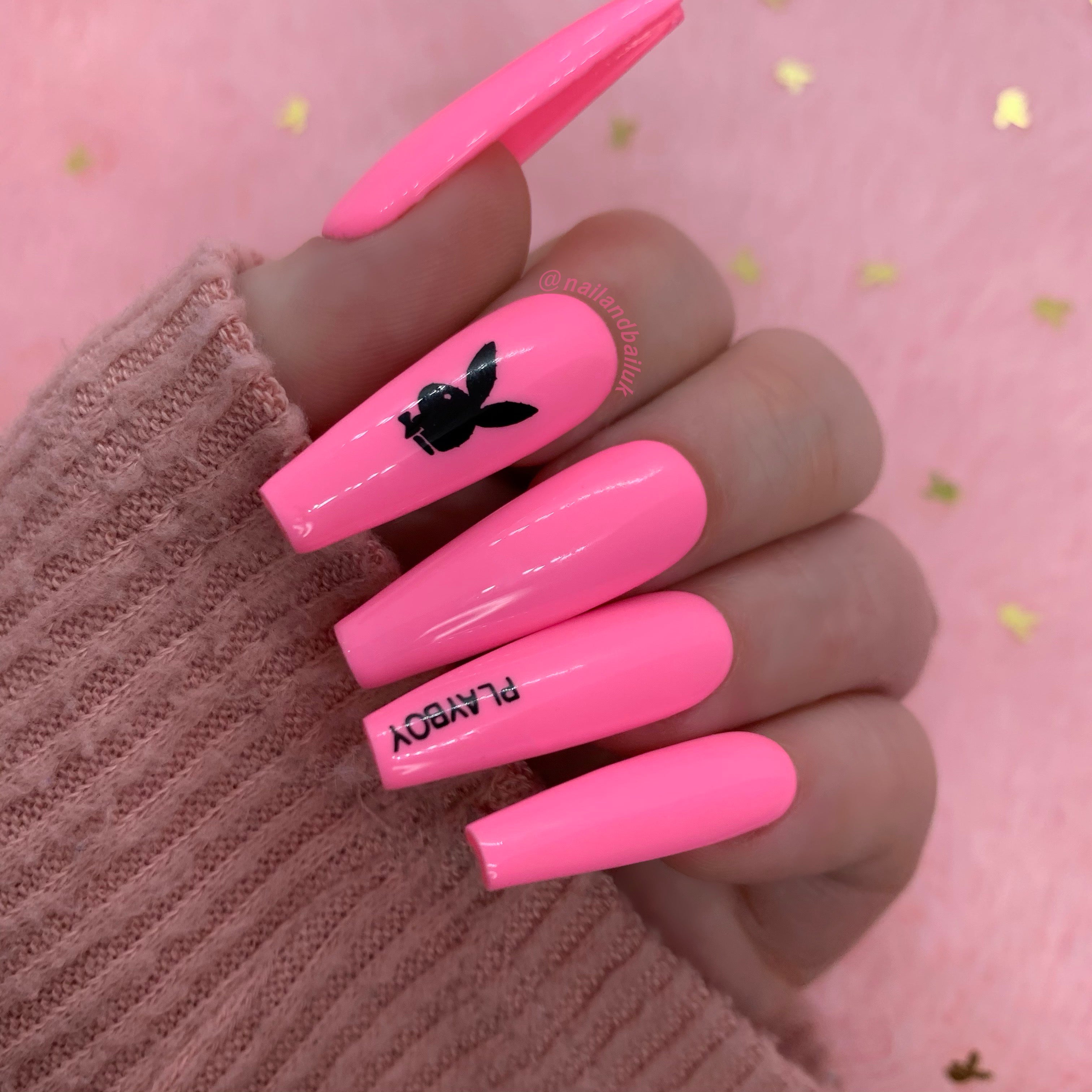 Pink press-on nails with black bunny-inspired designer-style prints and glossy finish