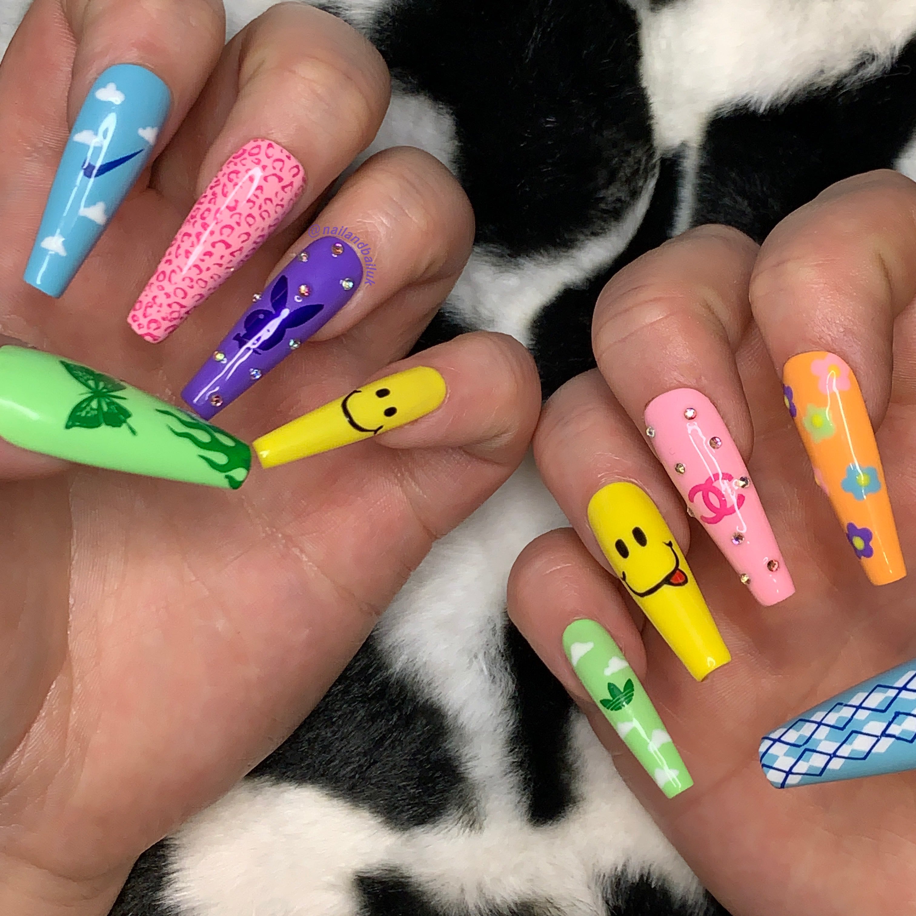 Colourful Y2K press-on nails with butterflies, flames, clouds, smiley faces, cheetah print, and crystal details