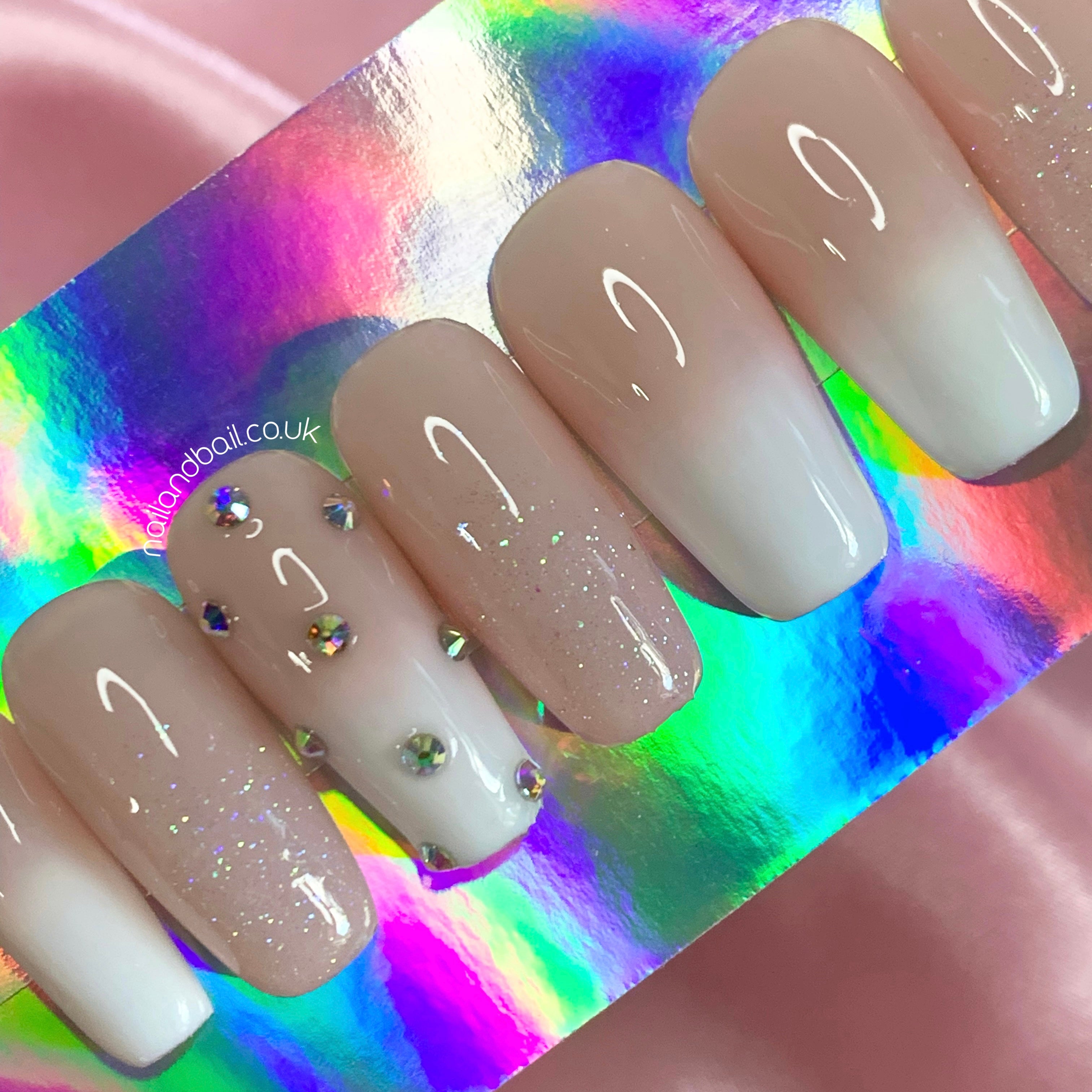 Silver crystal details arranged in a diamond shape on ombré press-on nails