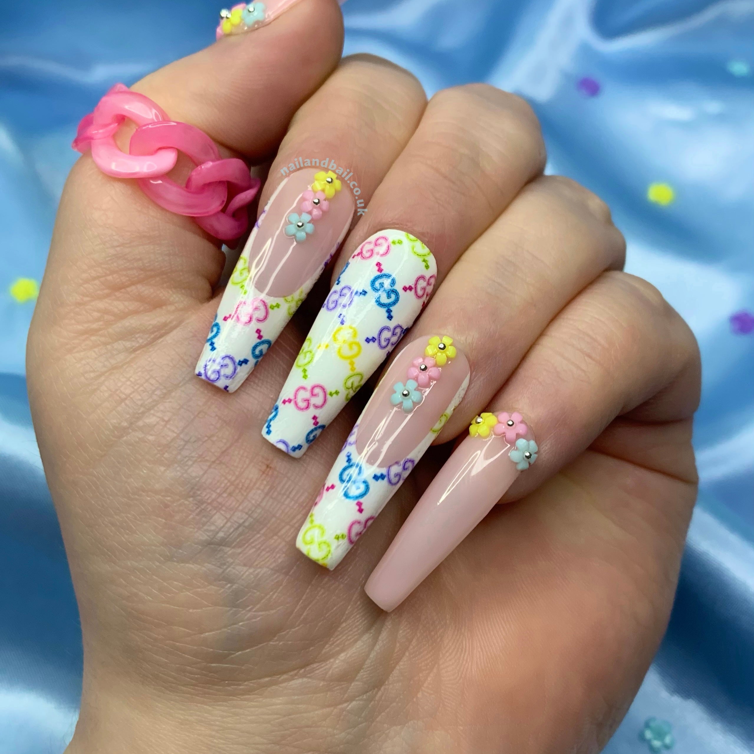 Multicolour designer-inspired press-on nails with 3D flower nail art and glam details