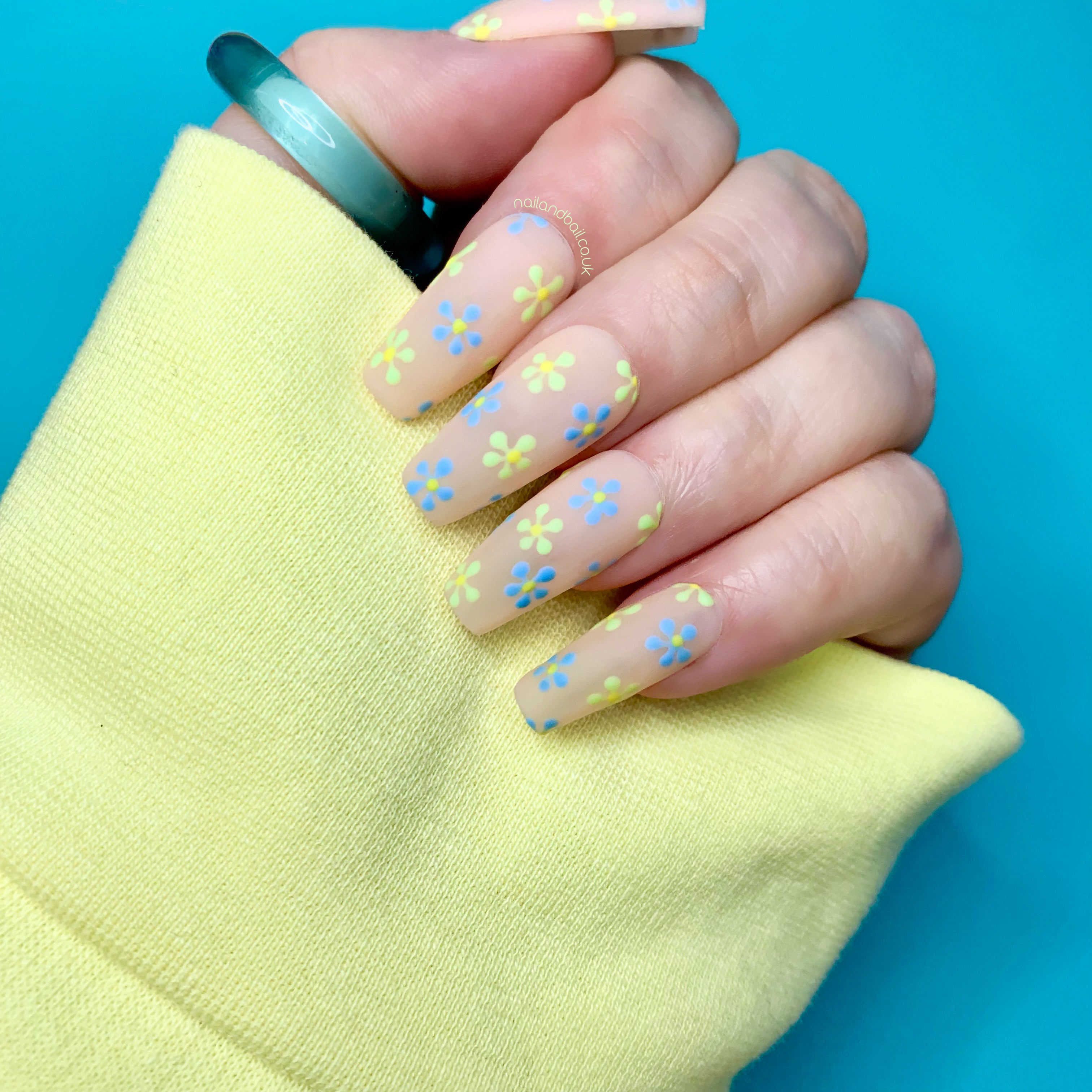 Matte nude press-on nails with hand-painted blue and green floral nail art