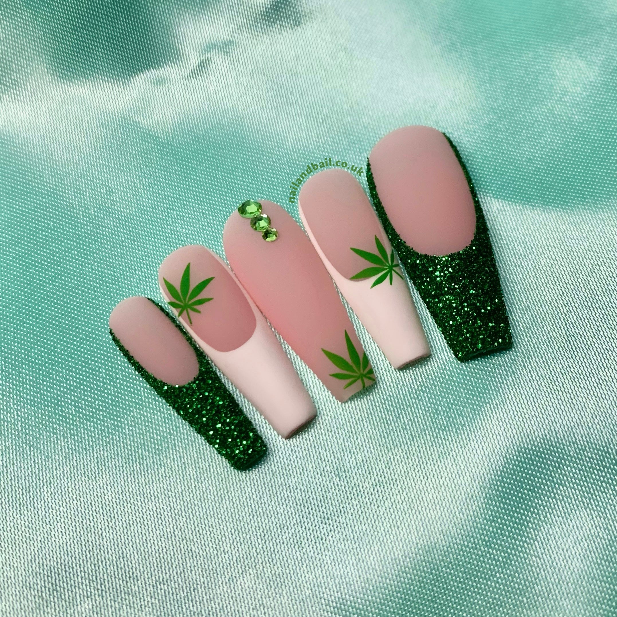 Glitter French tip press-on nails with green crystal details and matte finish