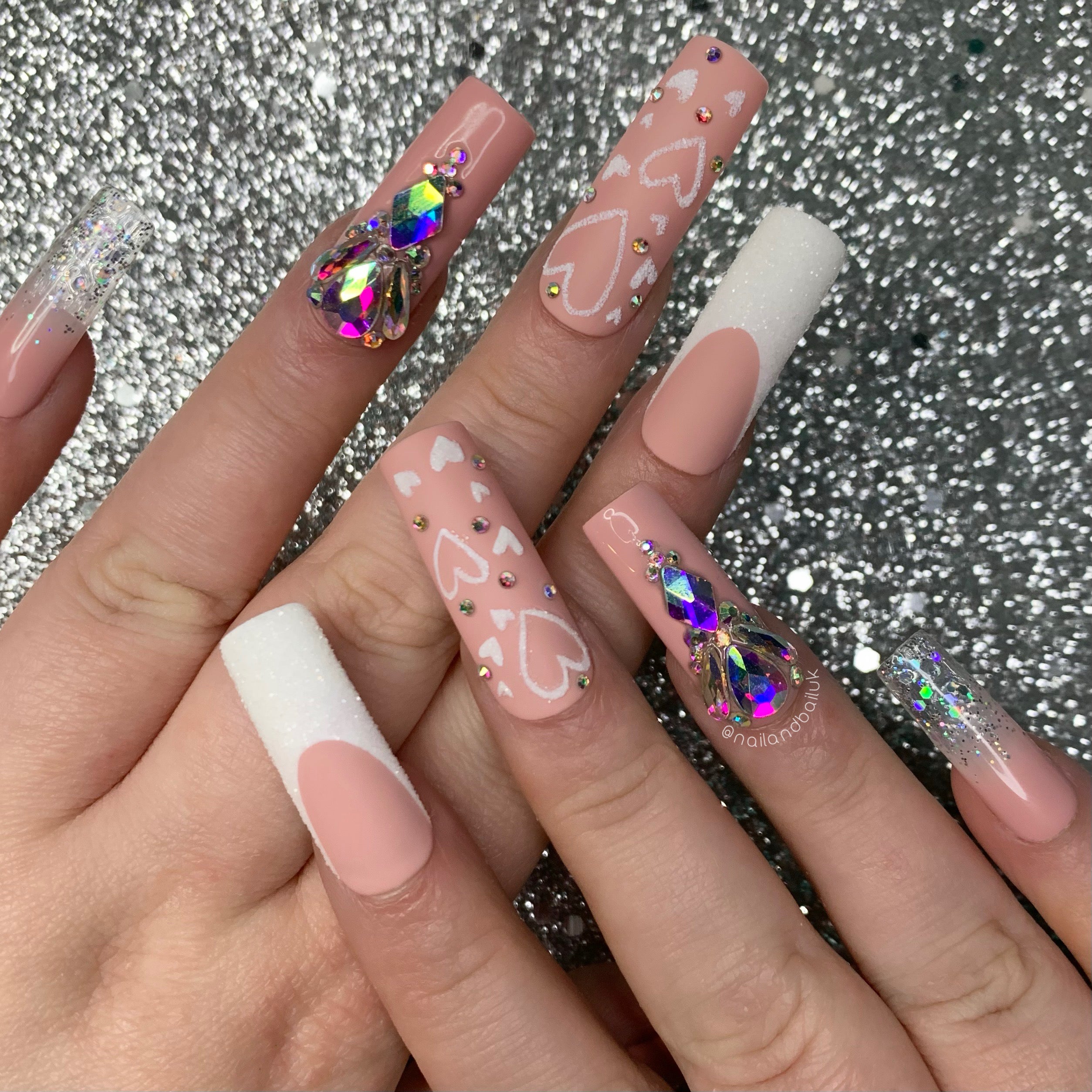Romantic press-on nails with sugared glitter hearts, silver crystals, and nude matte bases