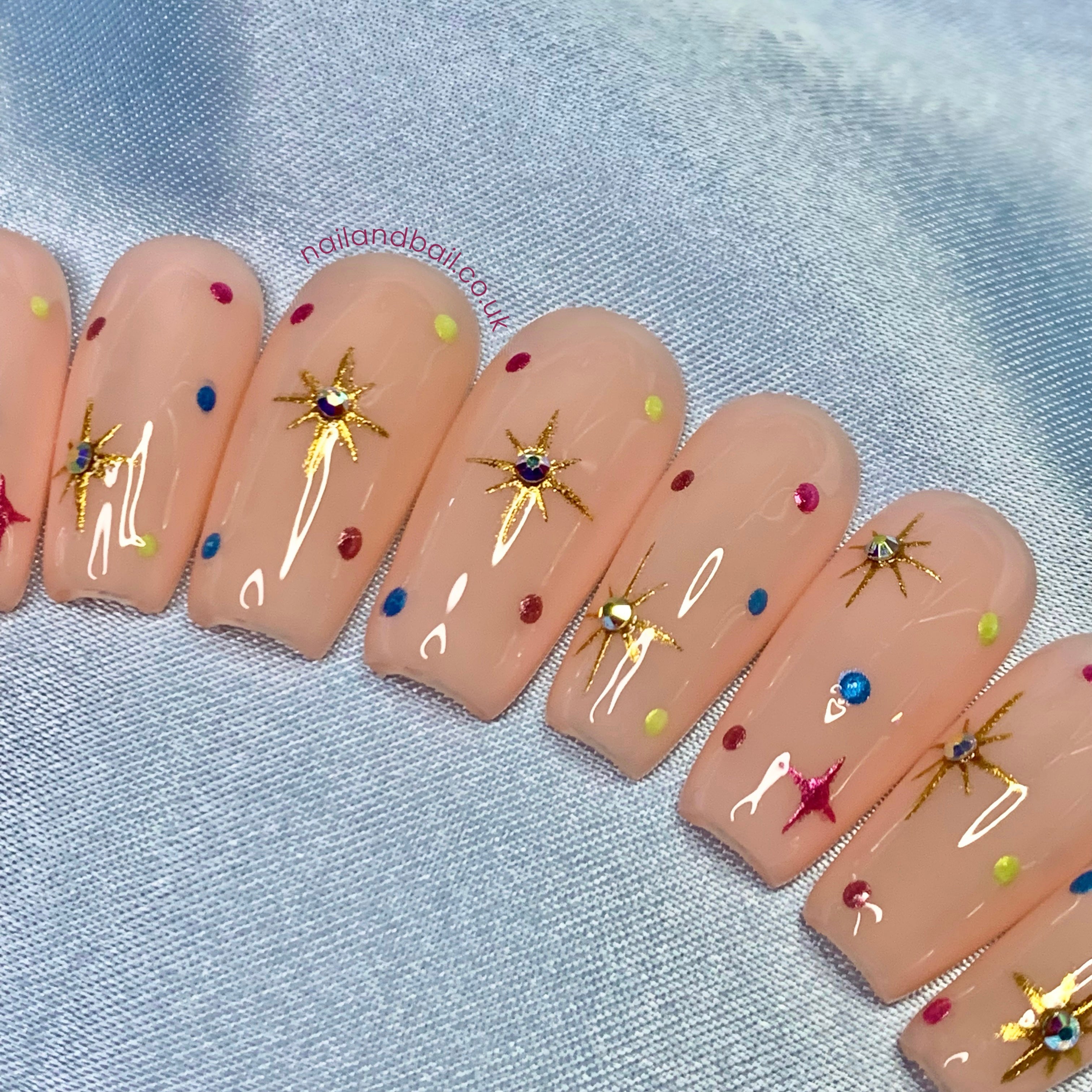 Gold chrome star nail art on elegant nude press-on nails