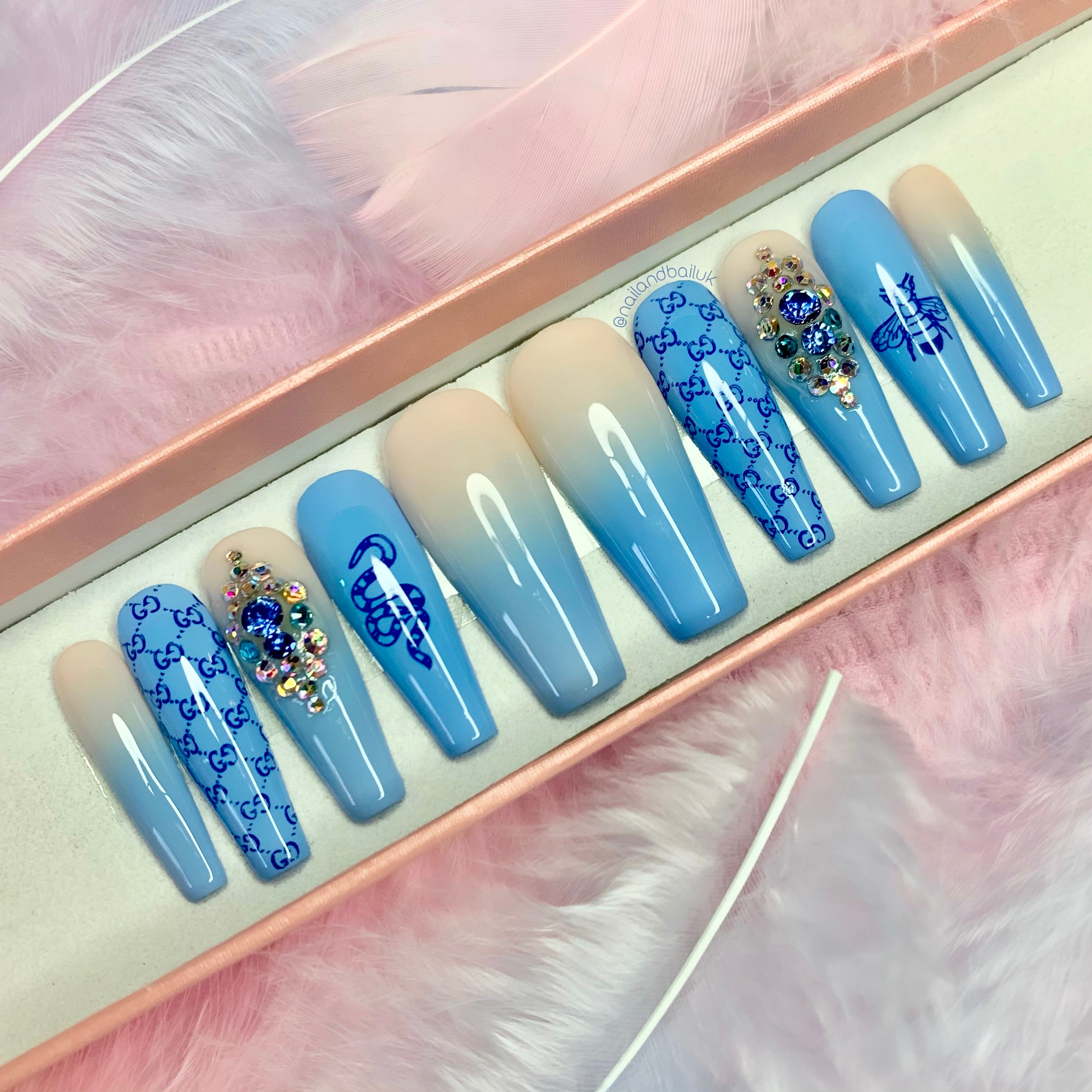 Blue and nude ombré press-on nails with bee and snake artwork and blue crystal embellishments