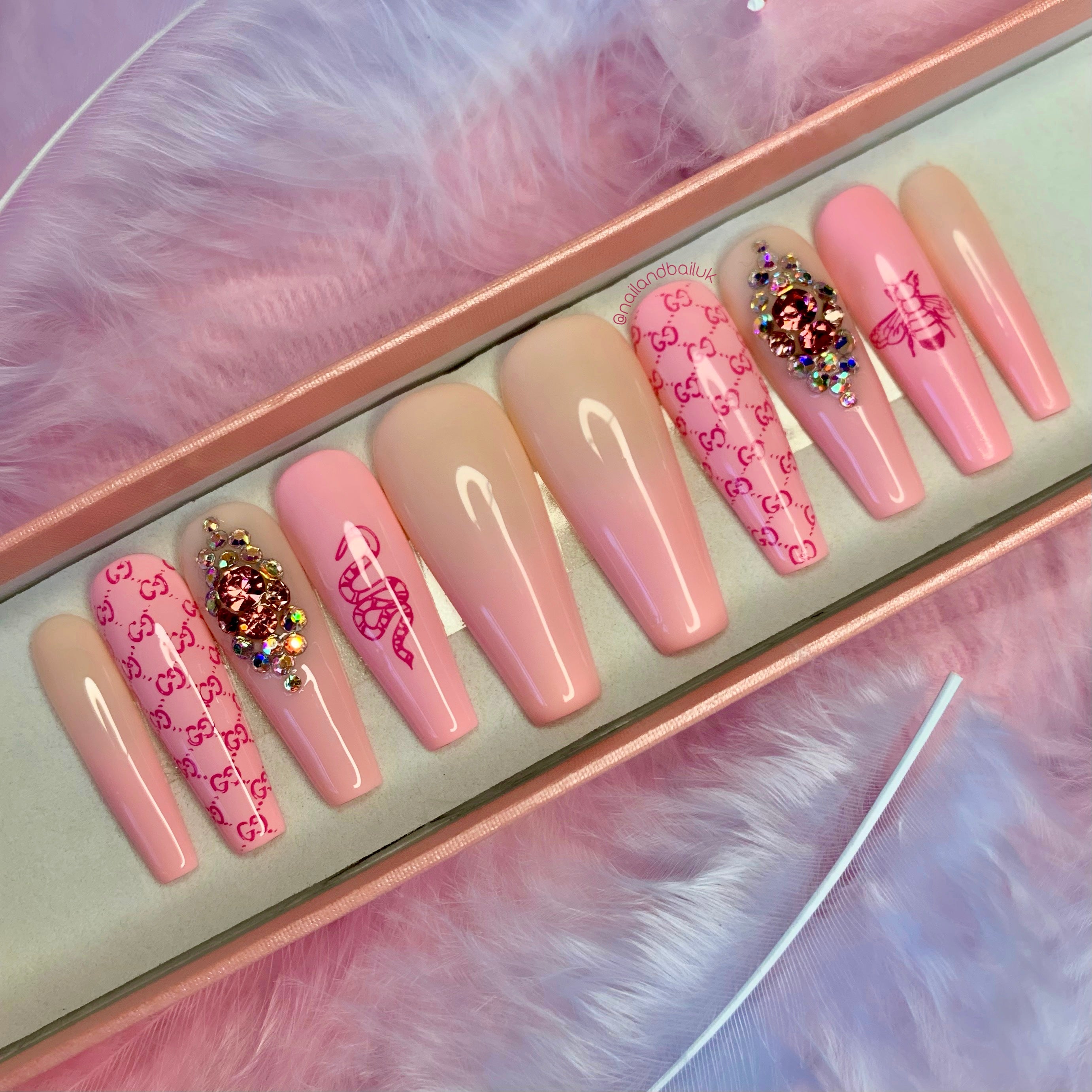 Pink and nude ombré press-on nails with bee and snake artwork and pink crystal embellishments