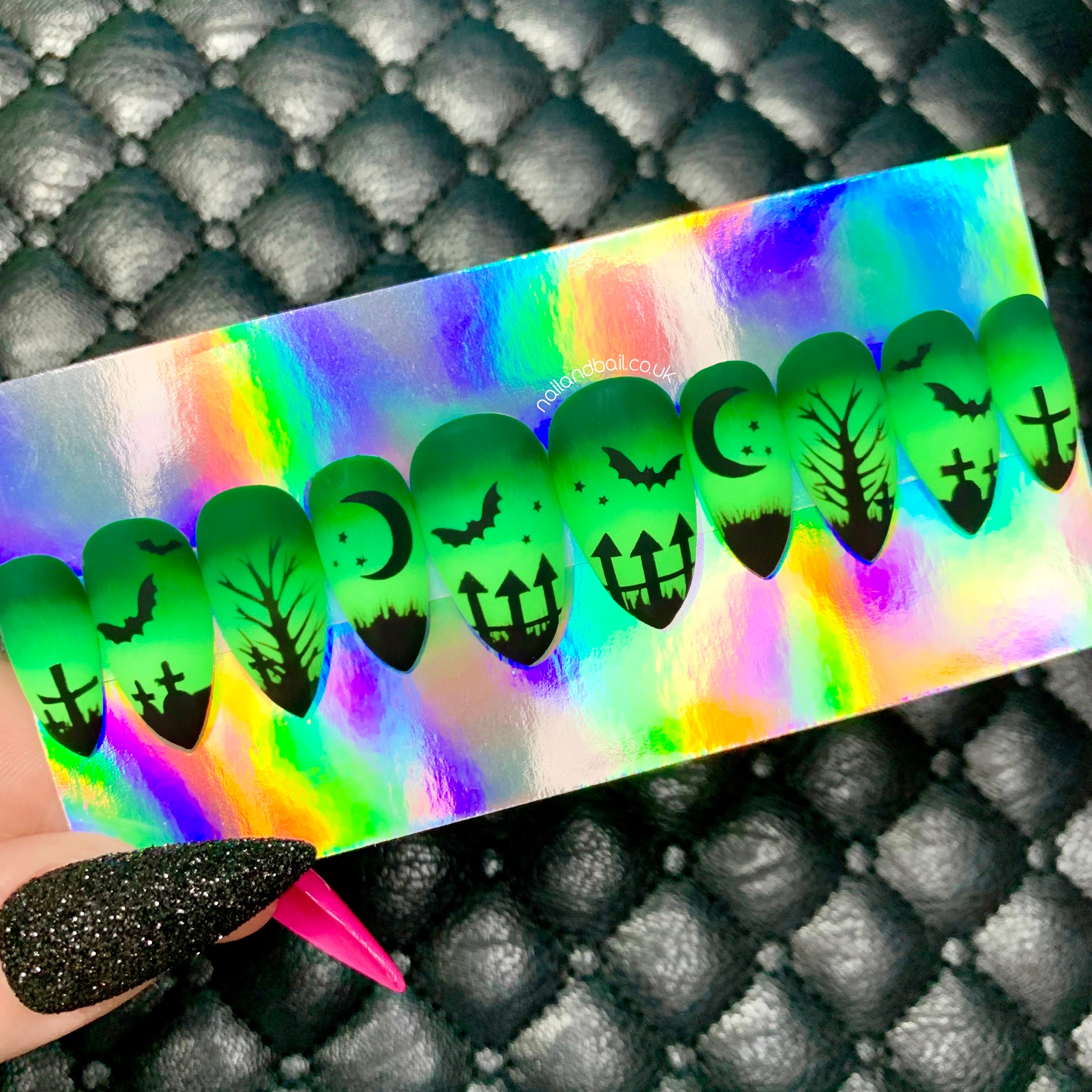 Green ombré Halloween press-on nails with graveyard silhouette nail art, bats, crosses, and matte finish