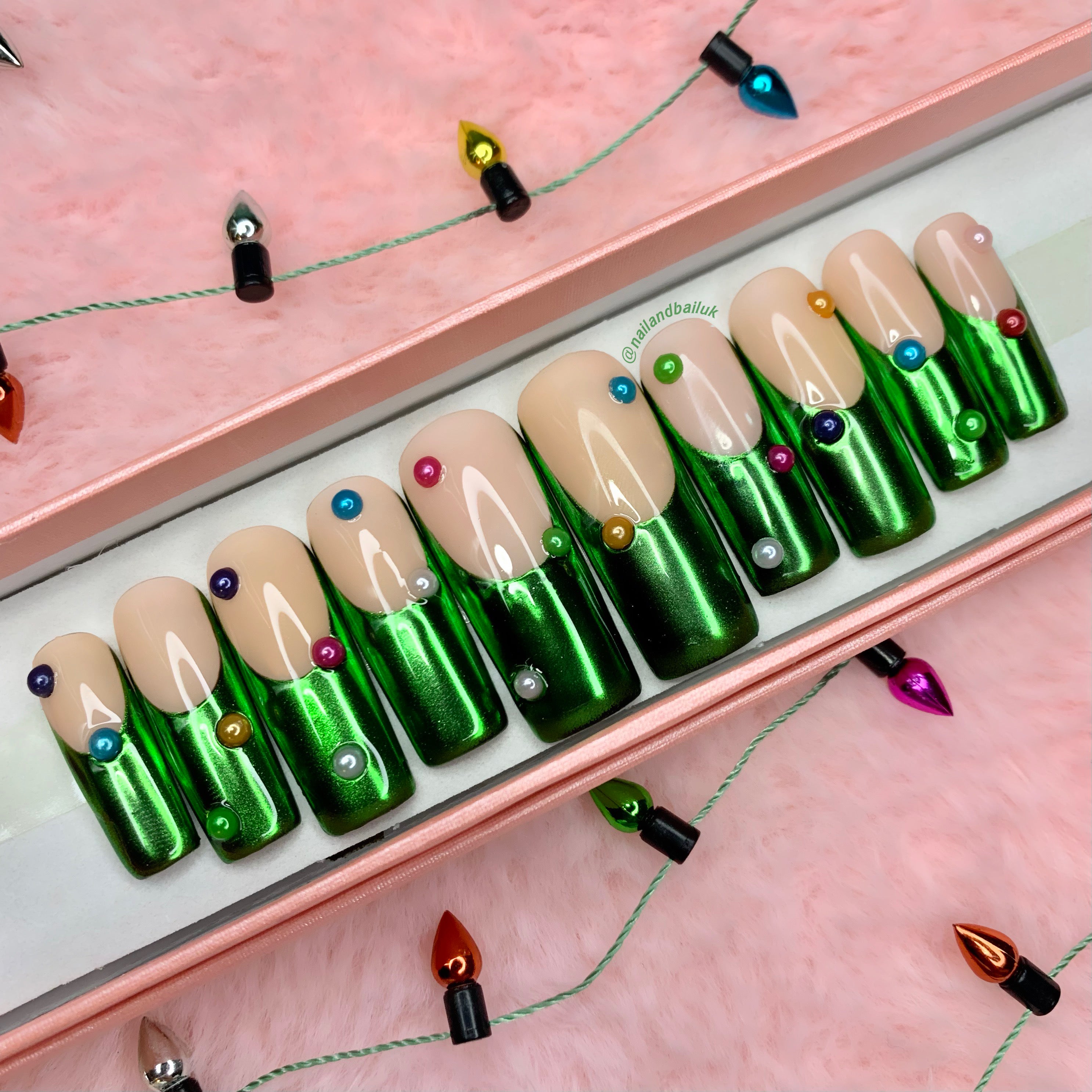 Green chrome French tip press-on nails with festive pearl nail art