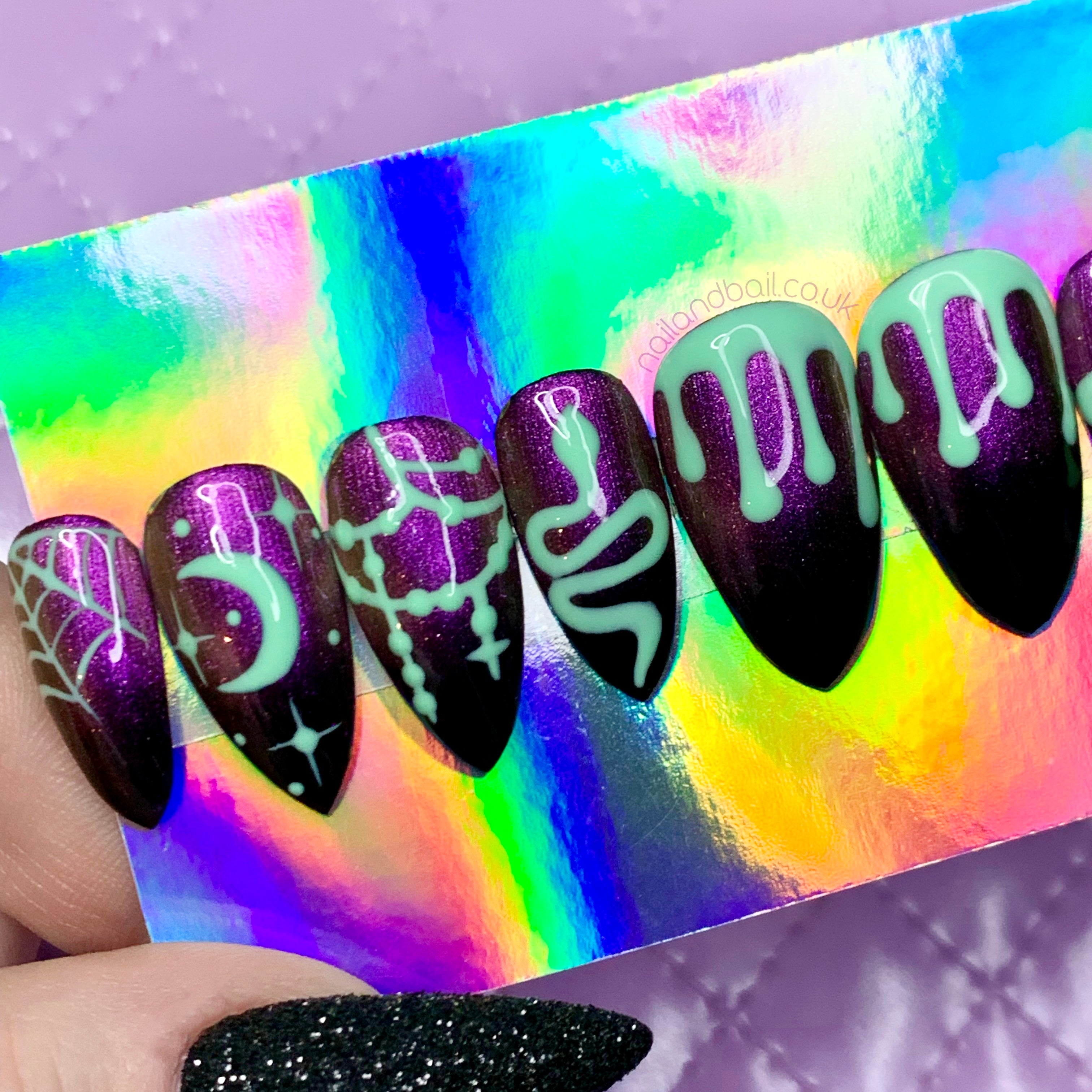 Green slime nail art on black and purple cat eye Halloween press-on nails
