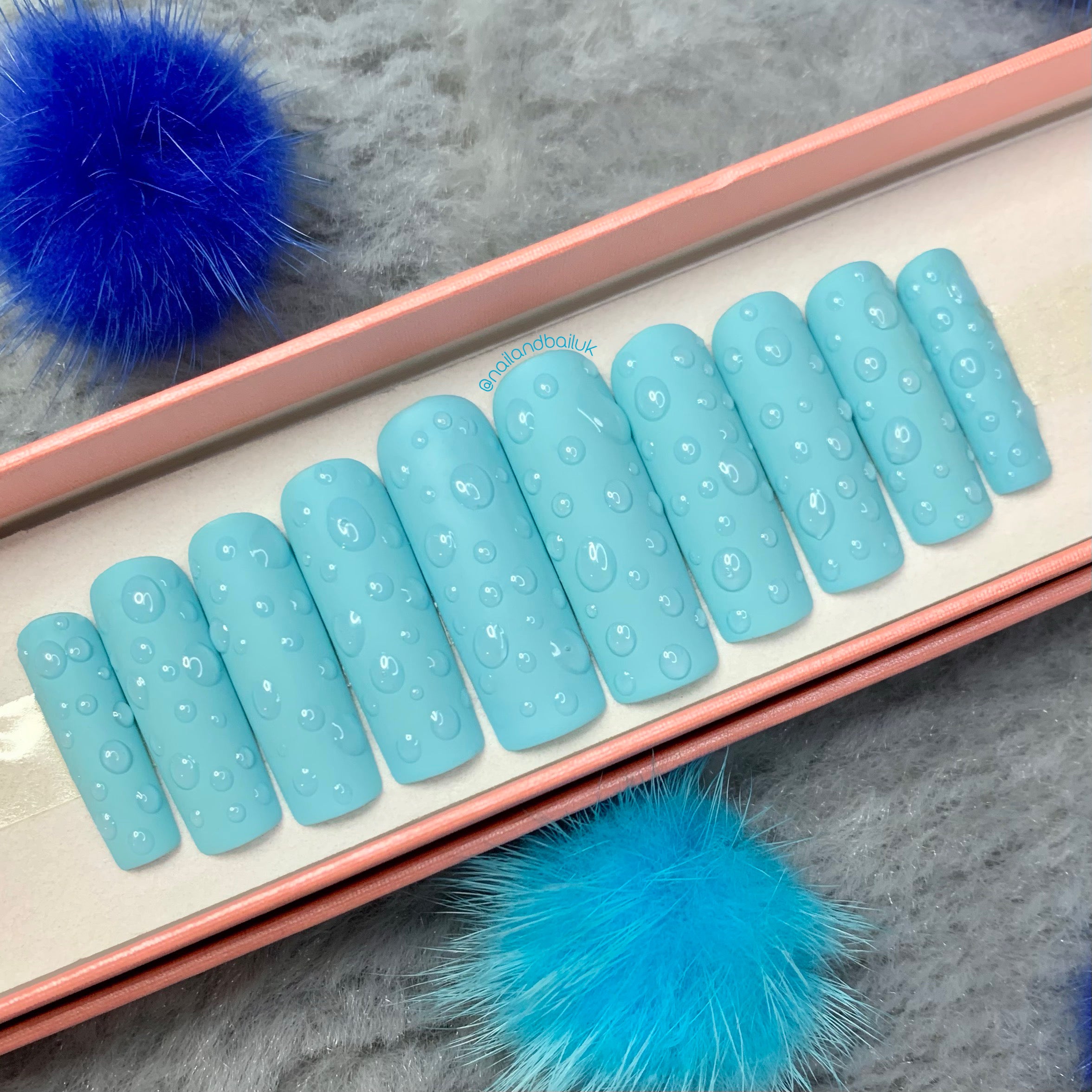 Matte baby blue press-on nails with glossy water drip nail art and summer-inspired design