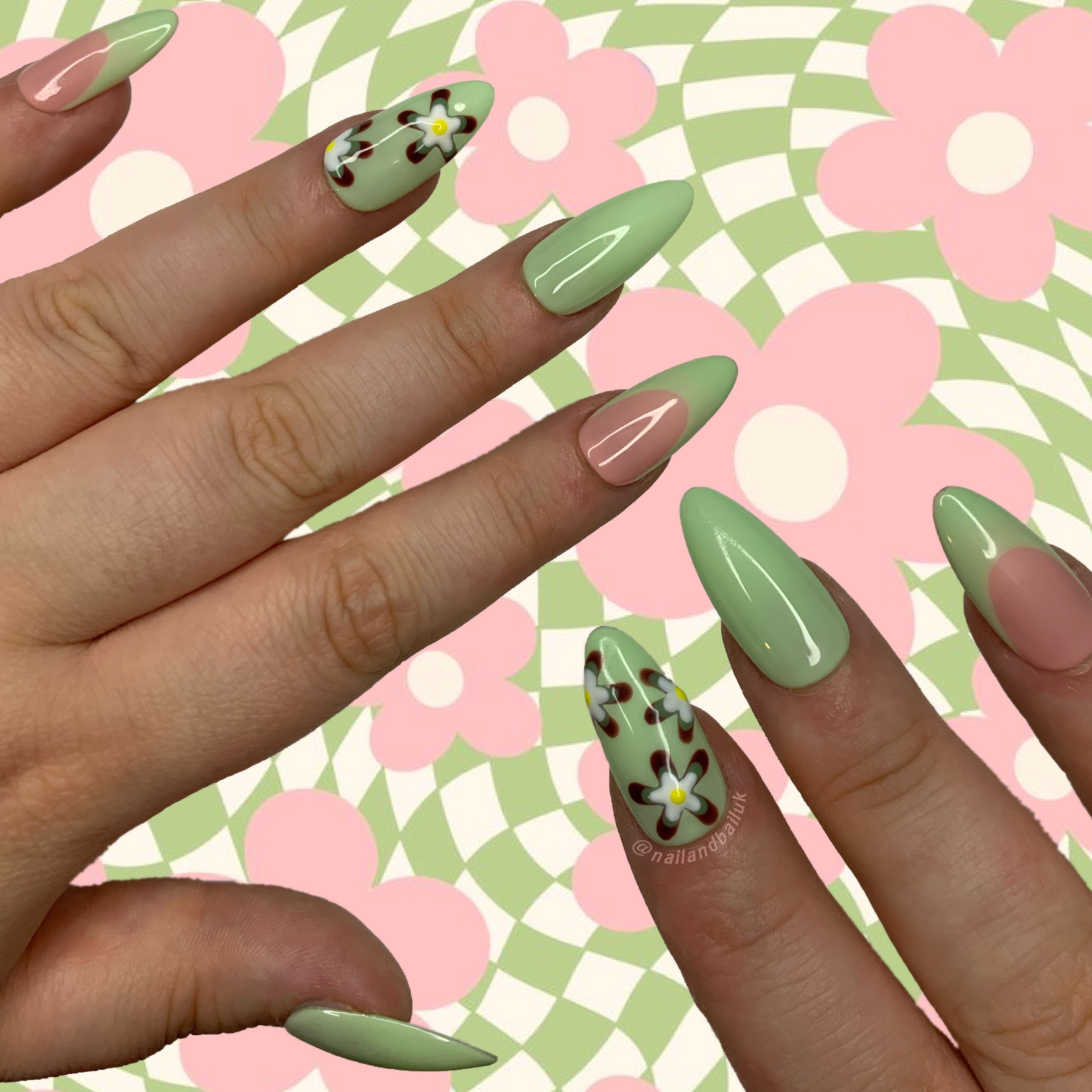 Nude press-on nails with green French tips and hand-painted 70s-inspired flower nail art