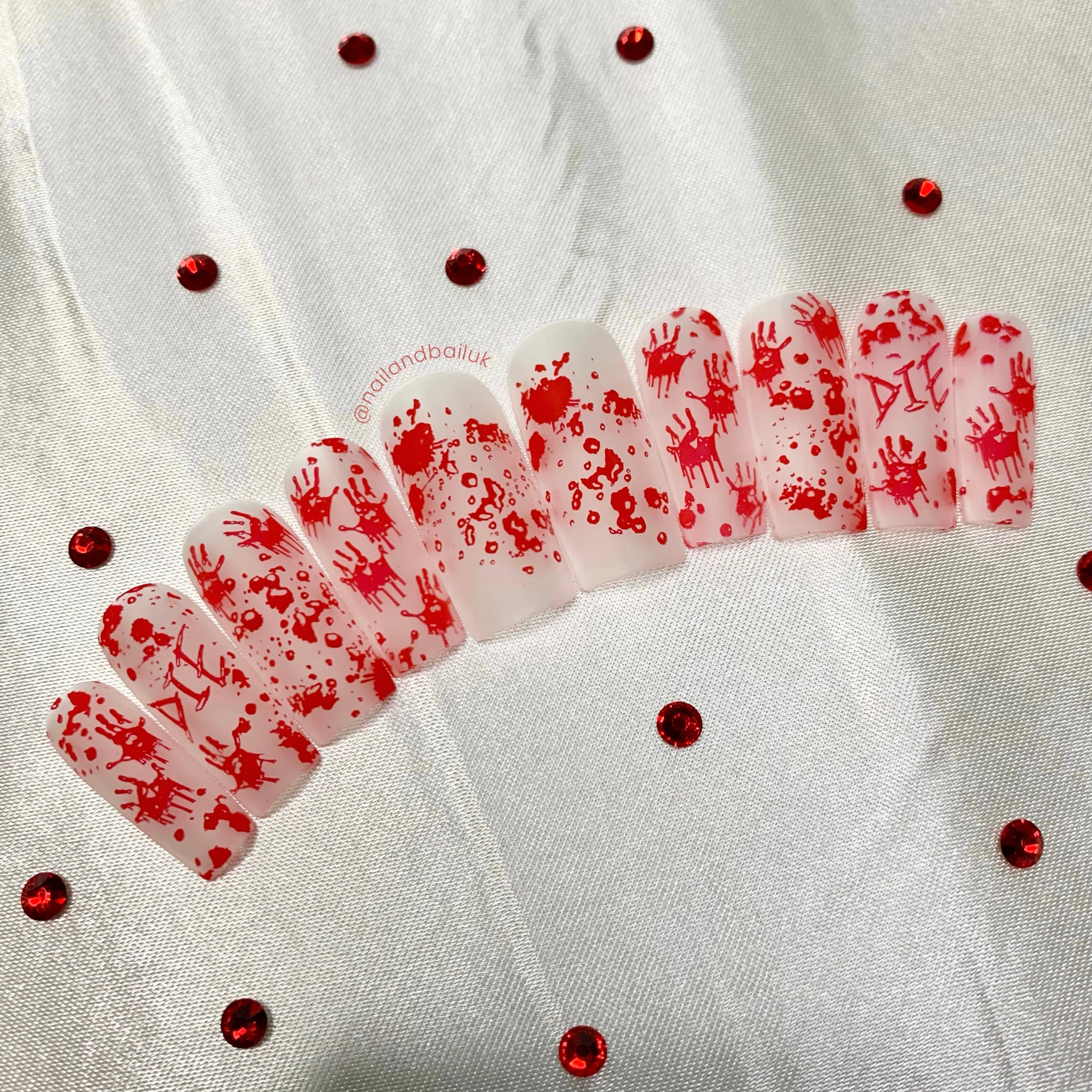Matte clear horror press-on nails with bloody handprints, blood splatter nail art, and eerie red lettering