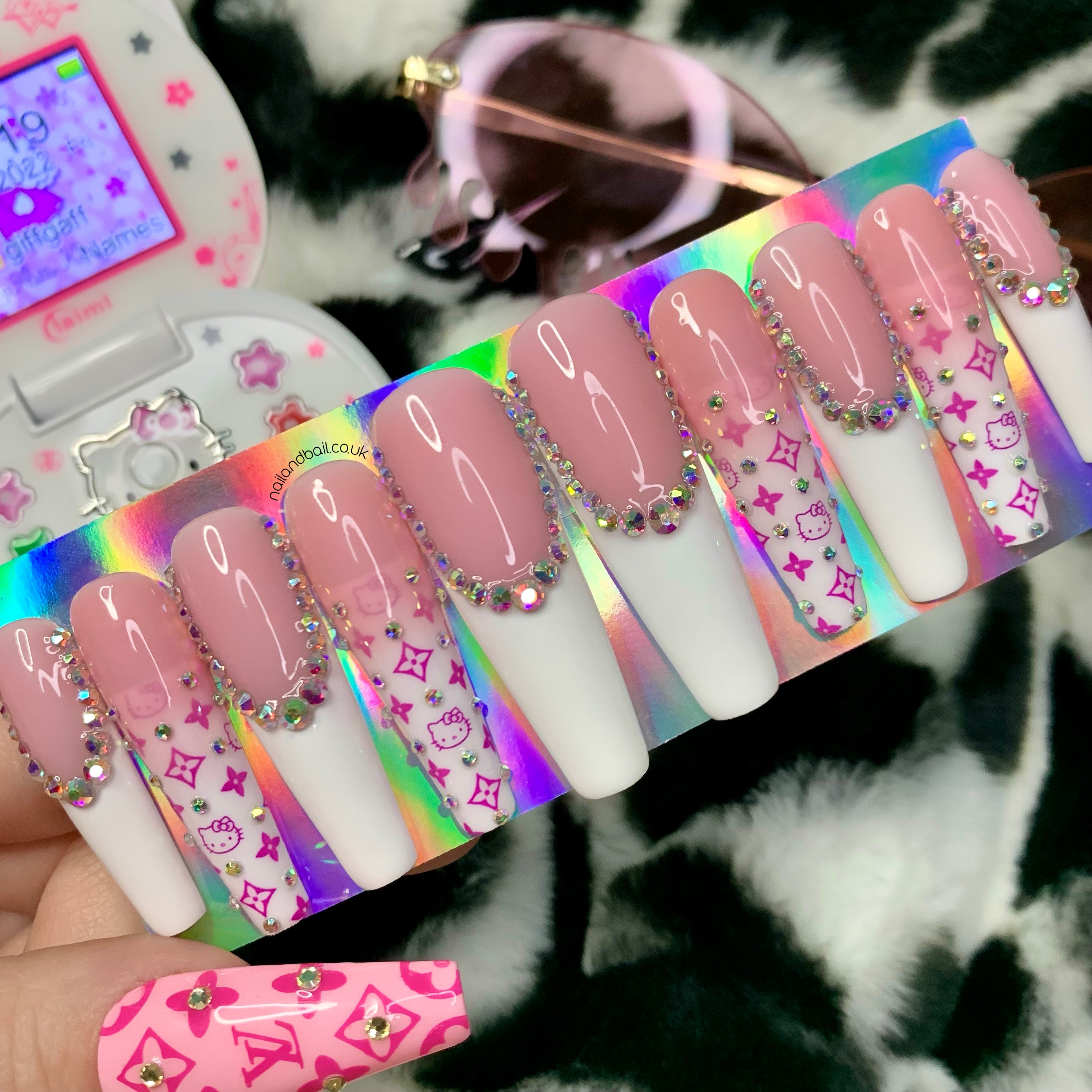 Pink and white ombré press-on nails with kitty-inspired designer-style prints and crystal details