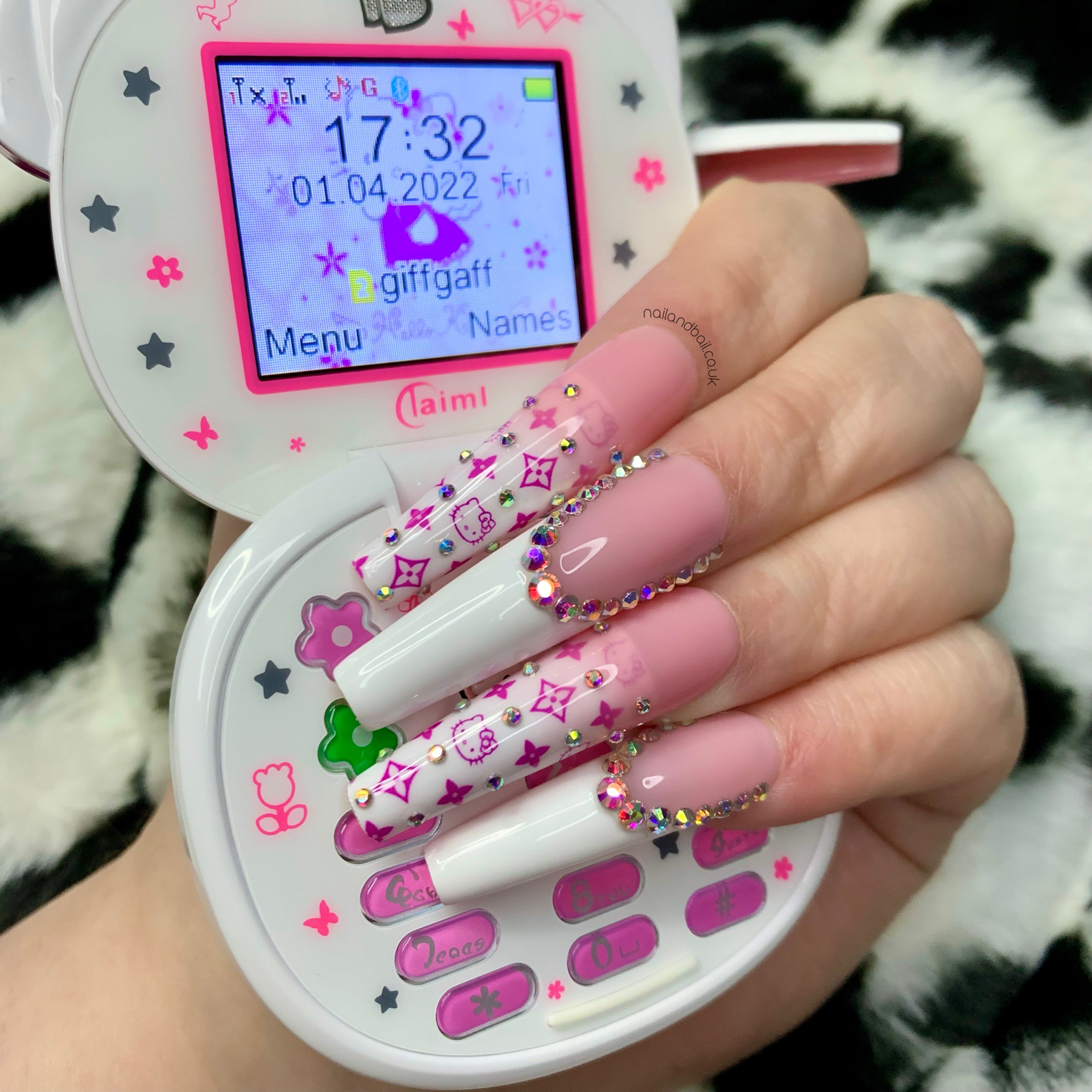 Nude pink and white French tip press-on nails with crystals and kitty-inspired designer-style nail art