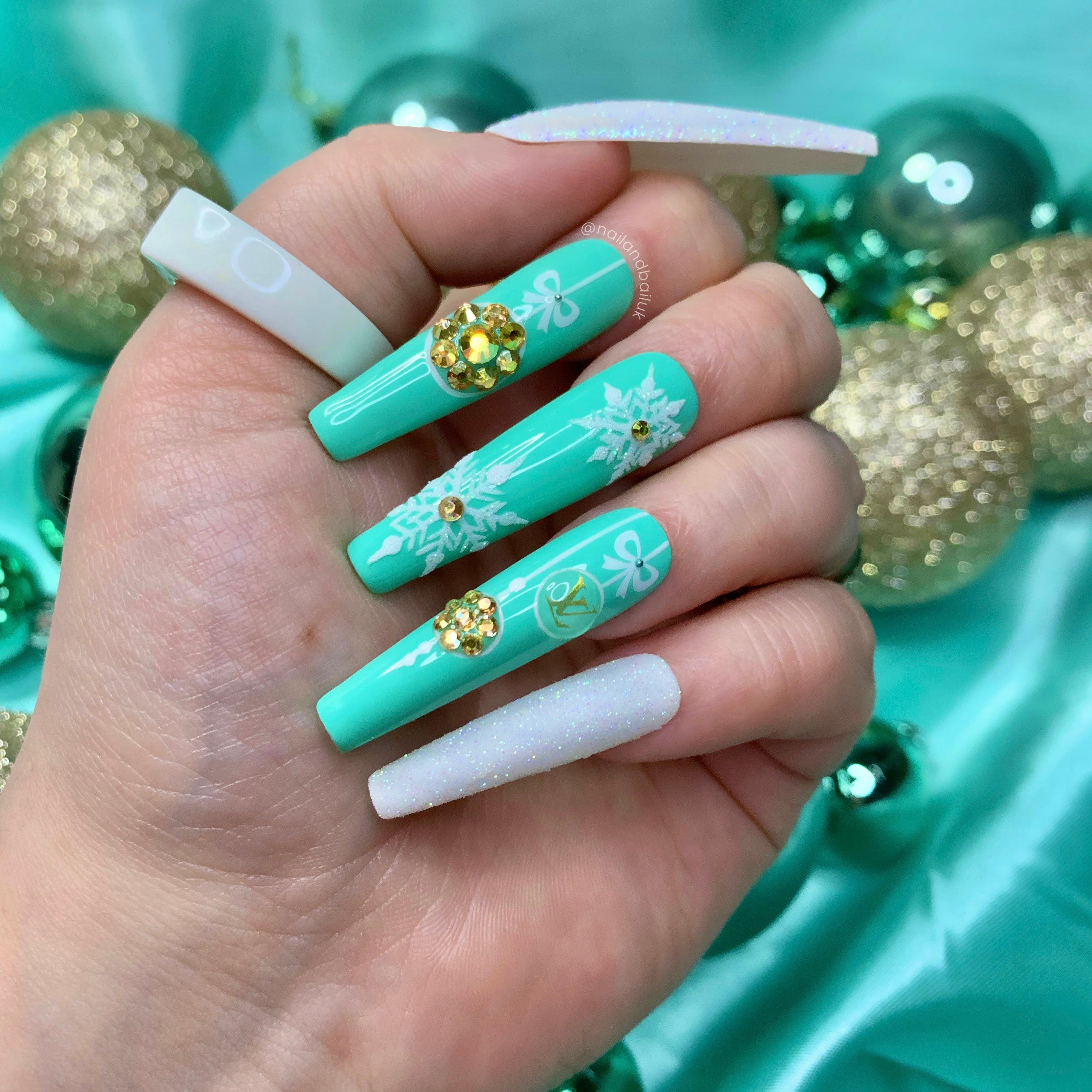 Luxury Christmas press-on nails with mint green nail art, gold crystal baubles, sugared glitter, and snowflakes
