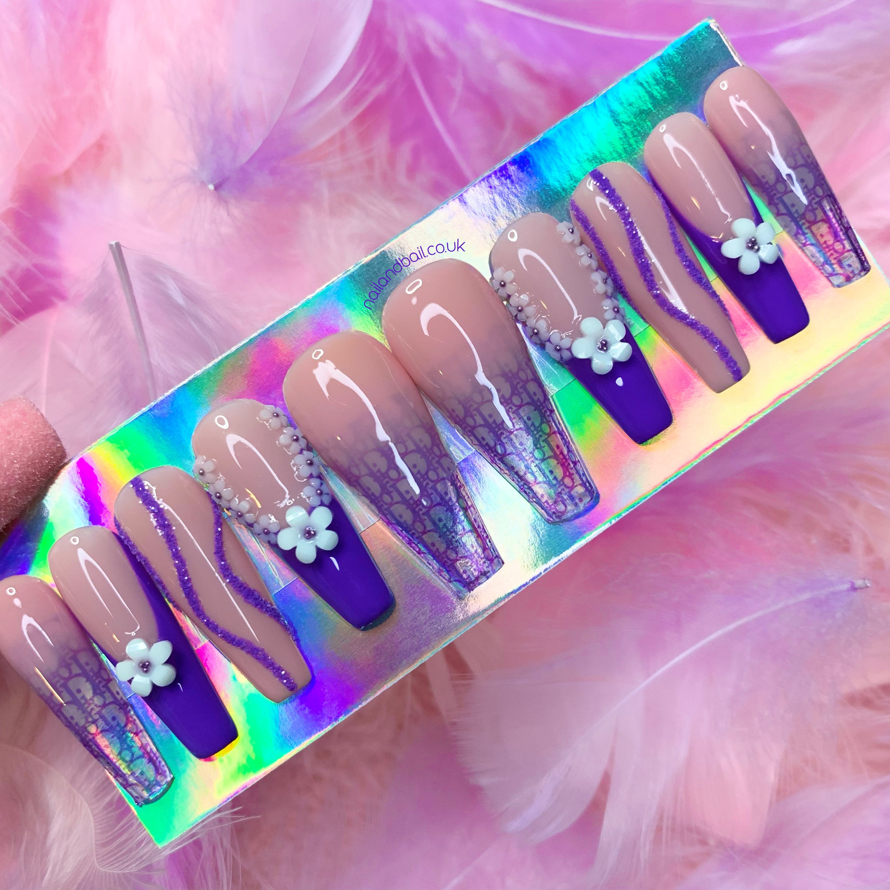 Nude ombré press-on nails with translucent tips and dark purple luxury-inspired details