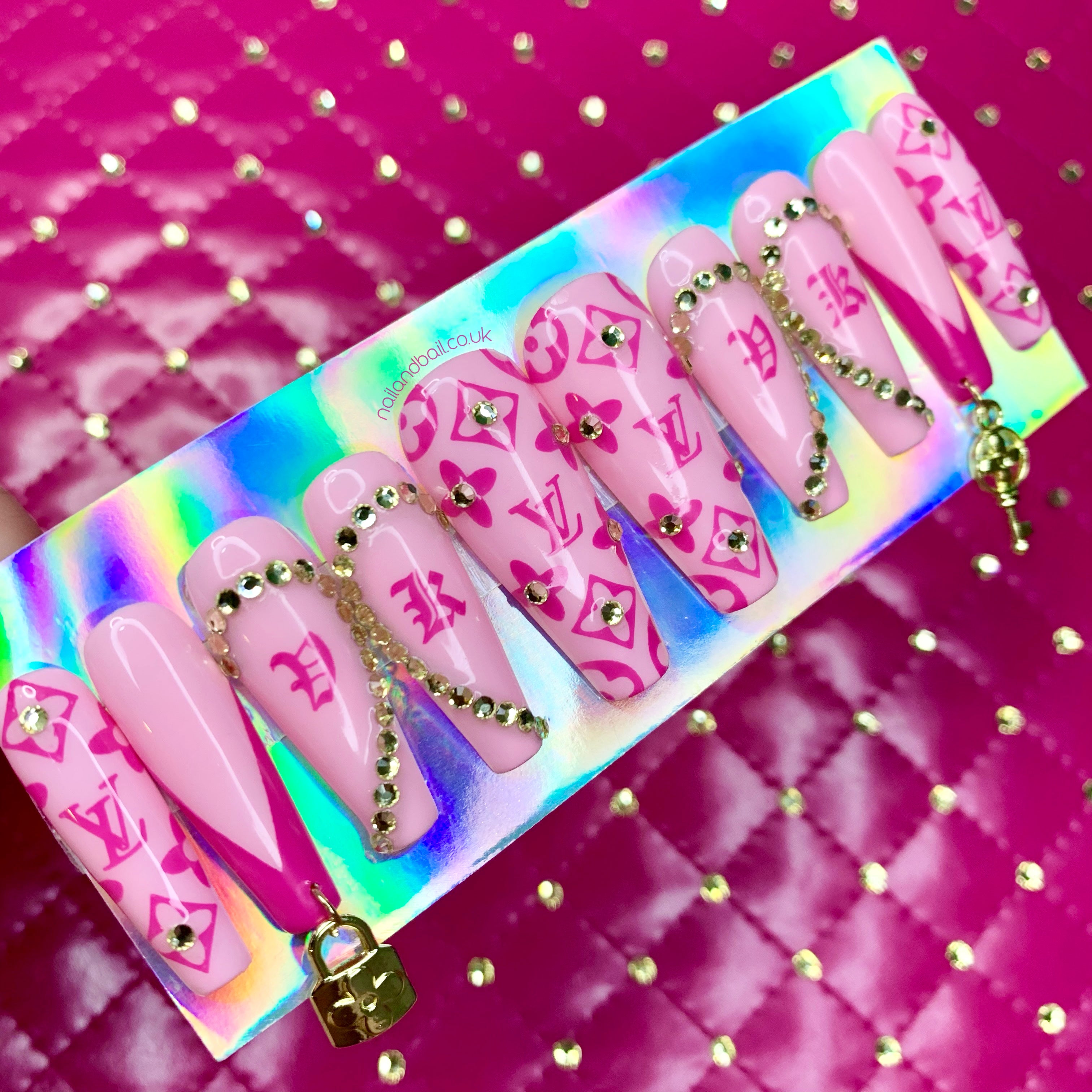 Pink press-on nails with custom crystal heart initials and champagne crystal detailing