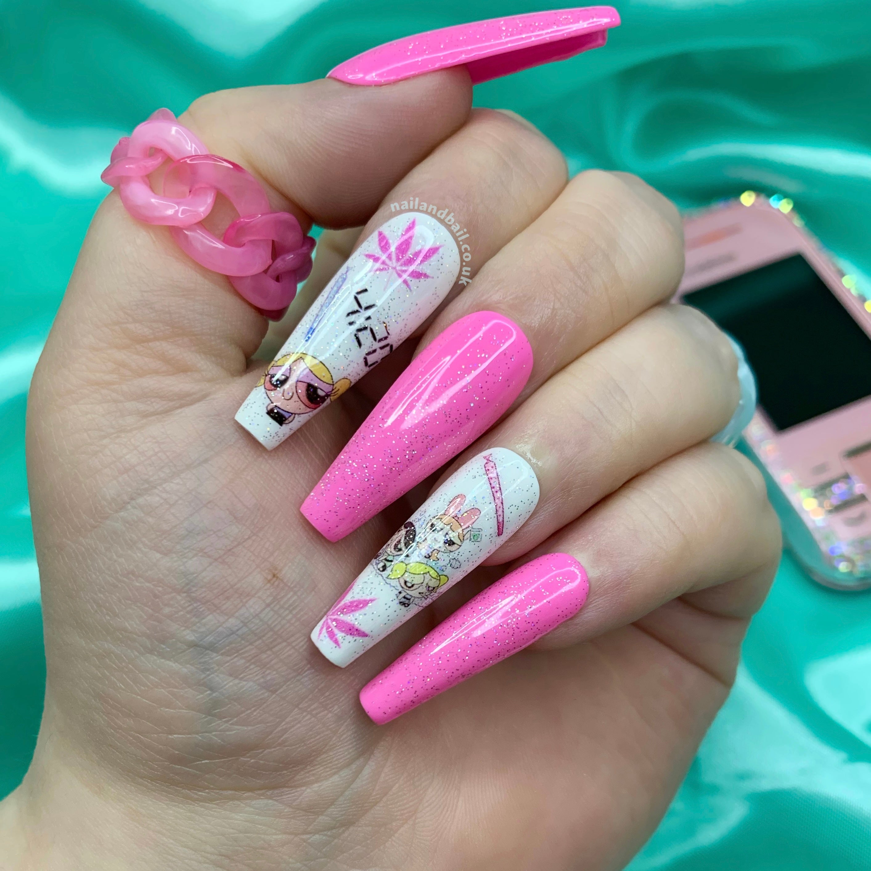 Powerpuff Girl-inspired press-on nails with pink glitter, white glitter, and cute cartoon nail art