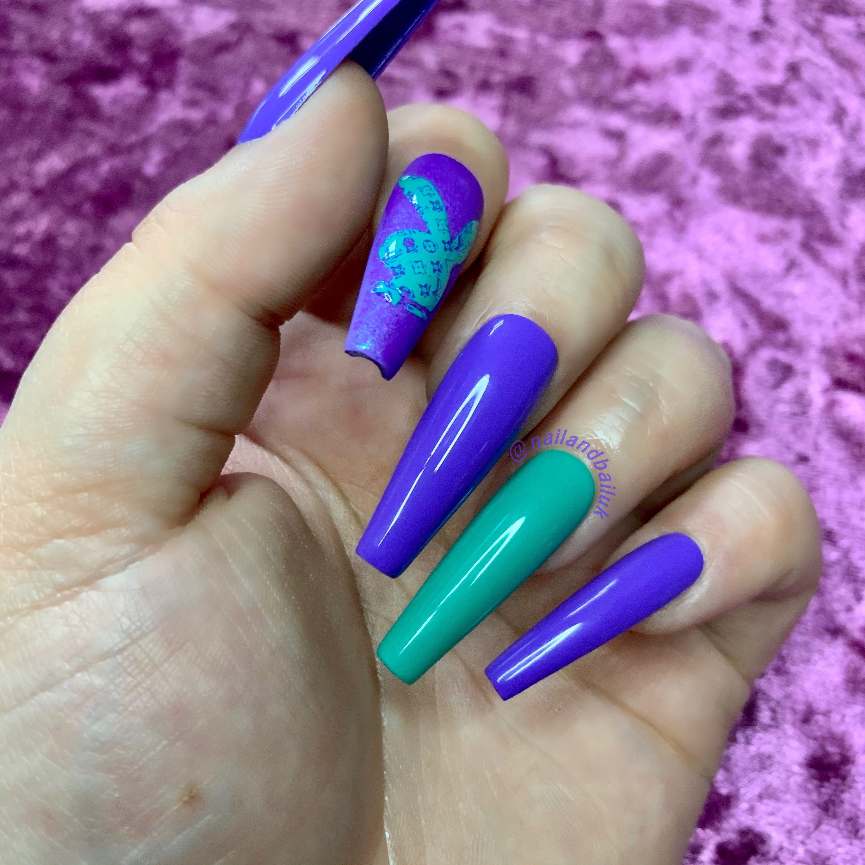 Purple and green press-on nails with glitter accents and raised bunny-inspired nail art
